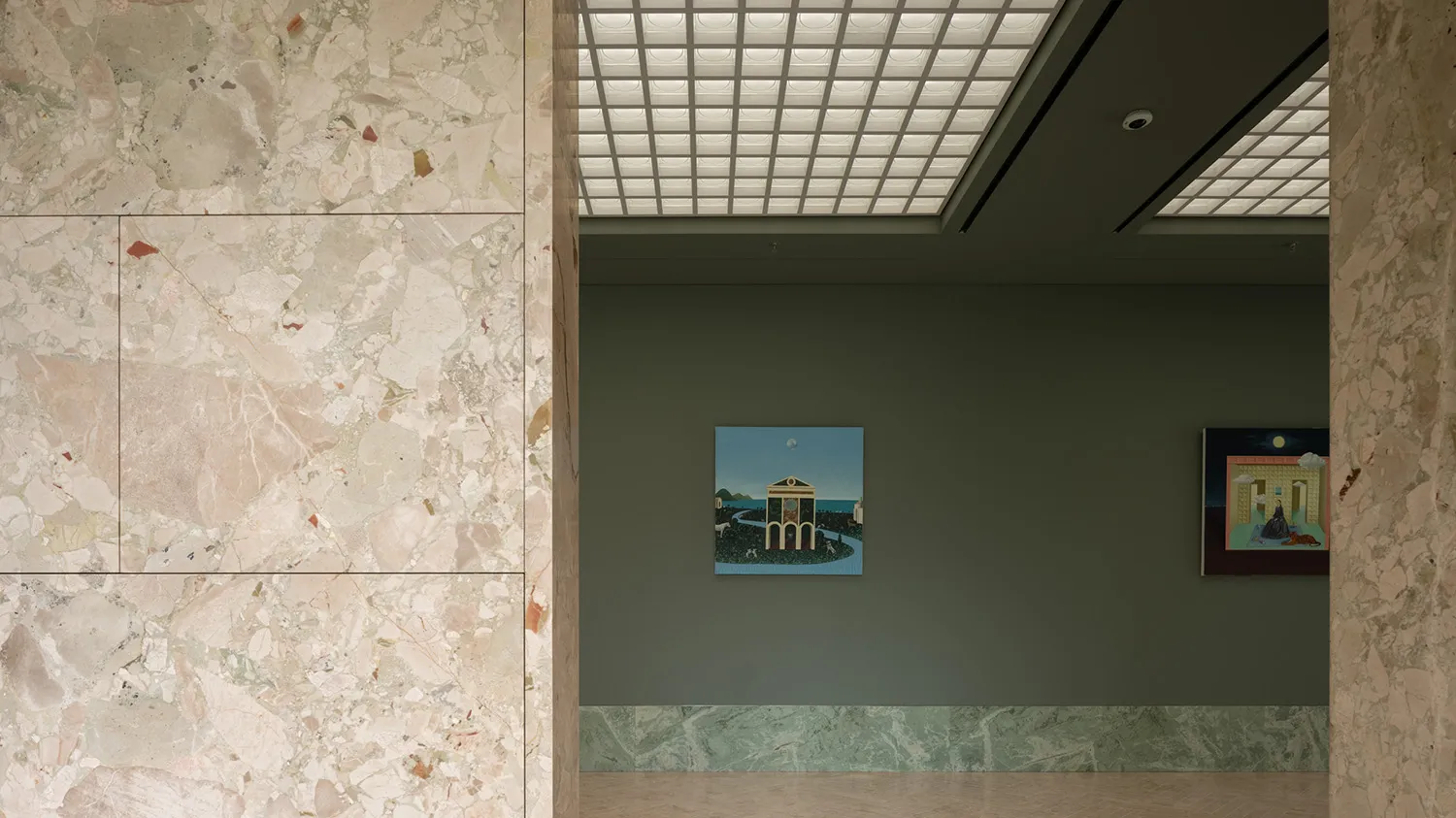 A calm and inviting gallery interior featuring a painting of a building with a clock tower and water feature, set against a neutral background