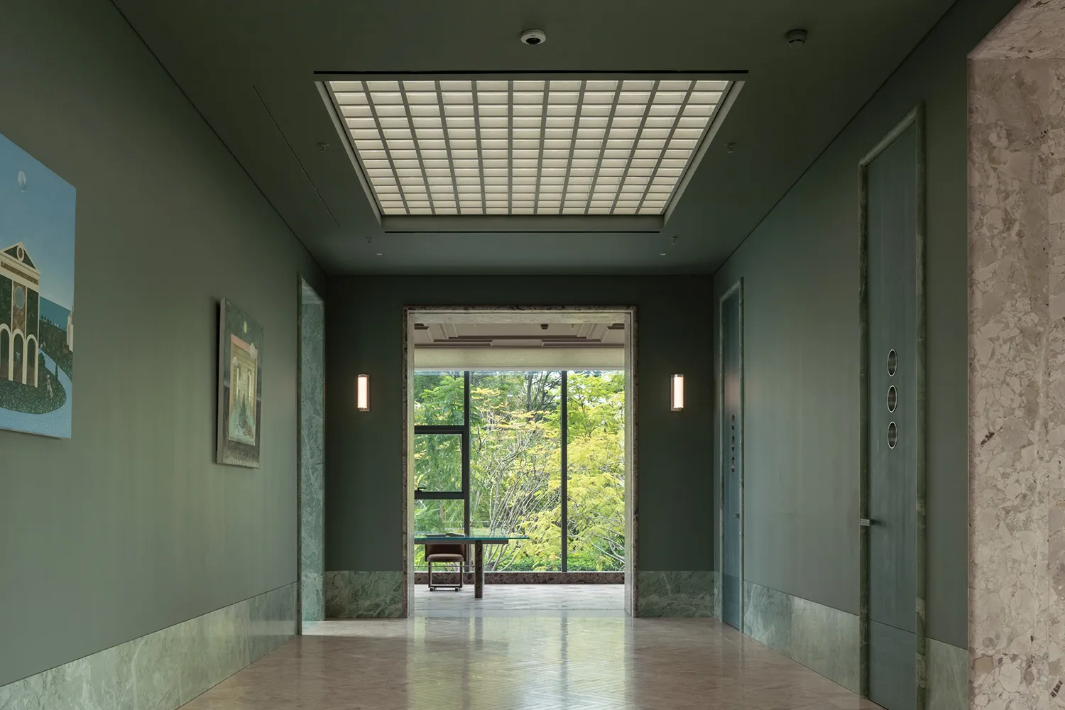 A bright and inviting hallway with a large window, two chairs, and natural light