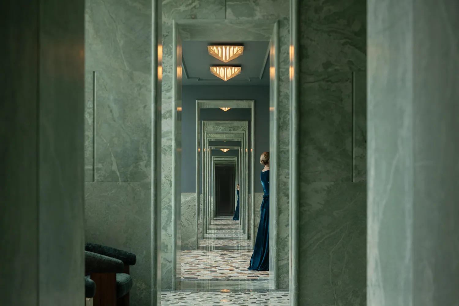 A dimly lit hallway with marble walls, lined with multiple doors on both sides, creating a mysterious atmosphere