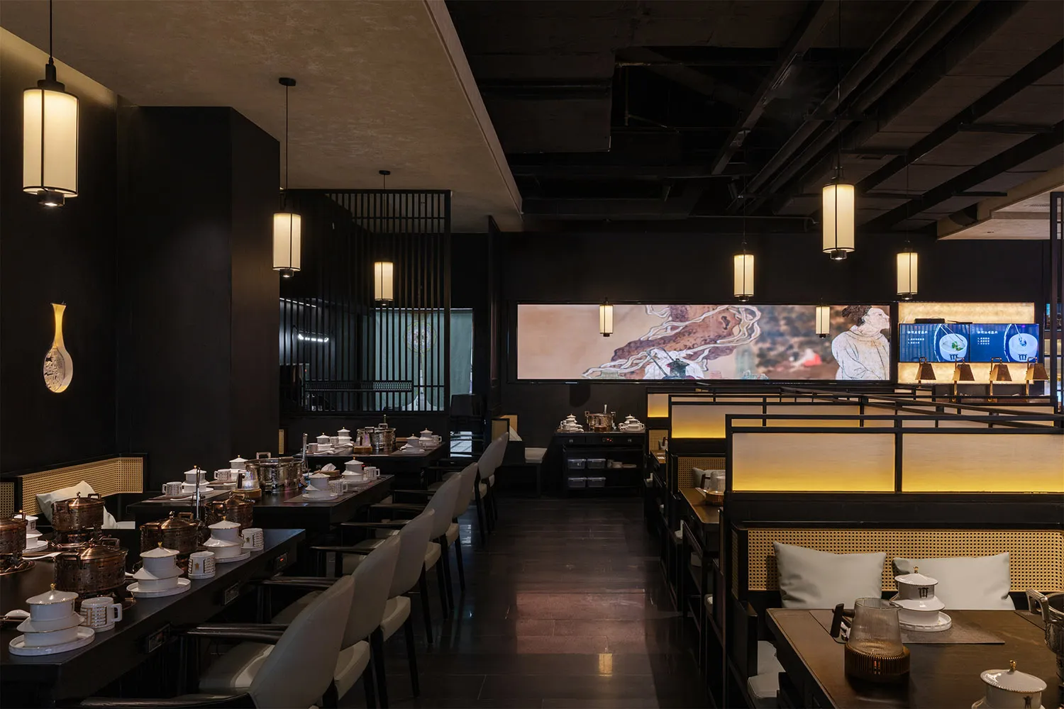 Modern restaurant interior with dining area, TVs on walls, and comfortable seating
