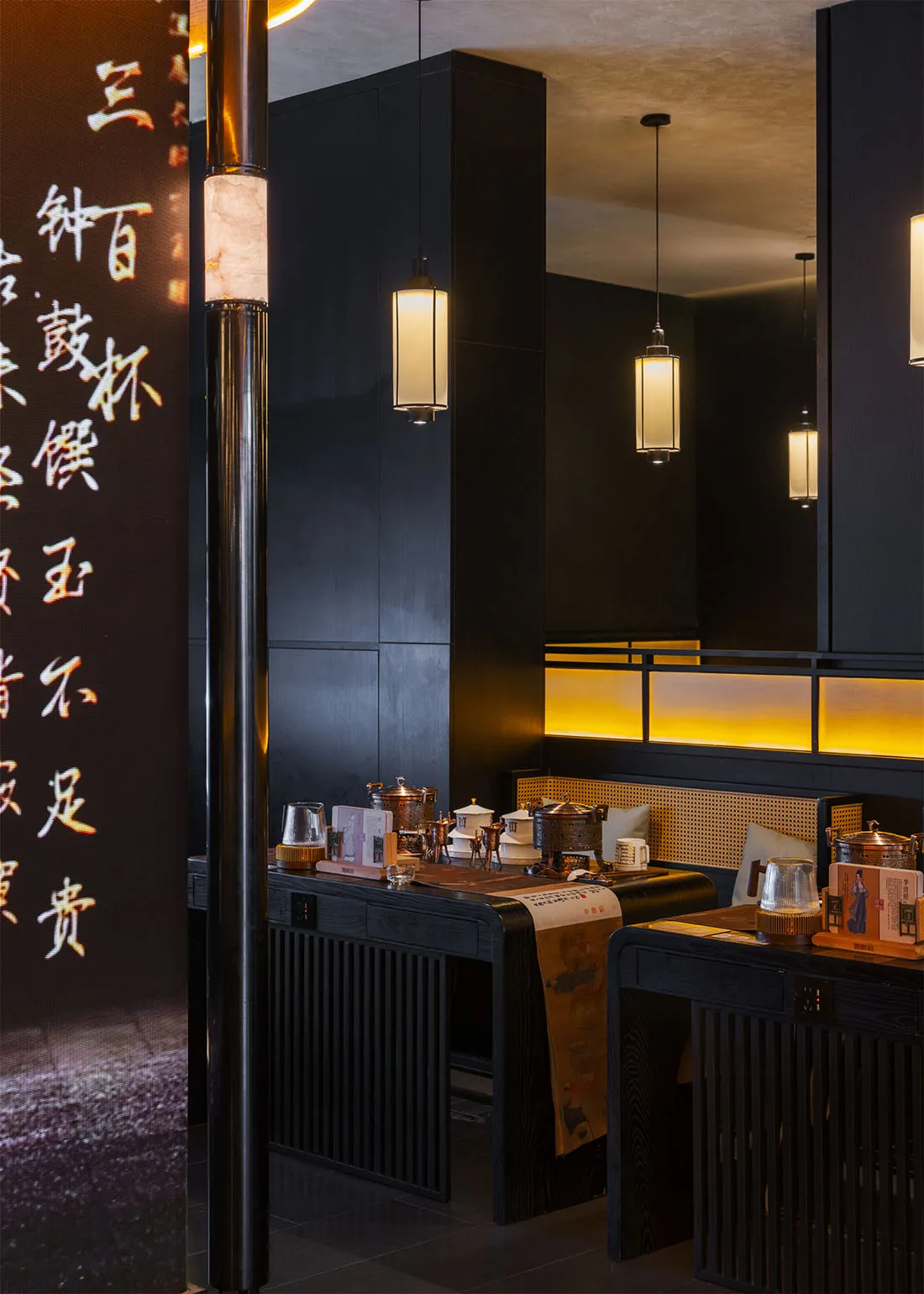 舒適亞洲餐廳內部，黑牆、餐桌、椅子，桌上擺放各式杯碗