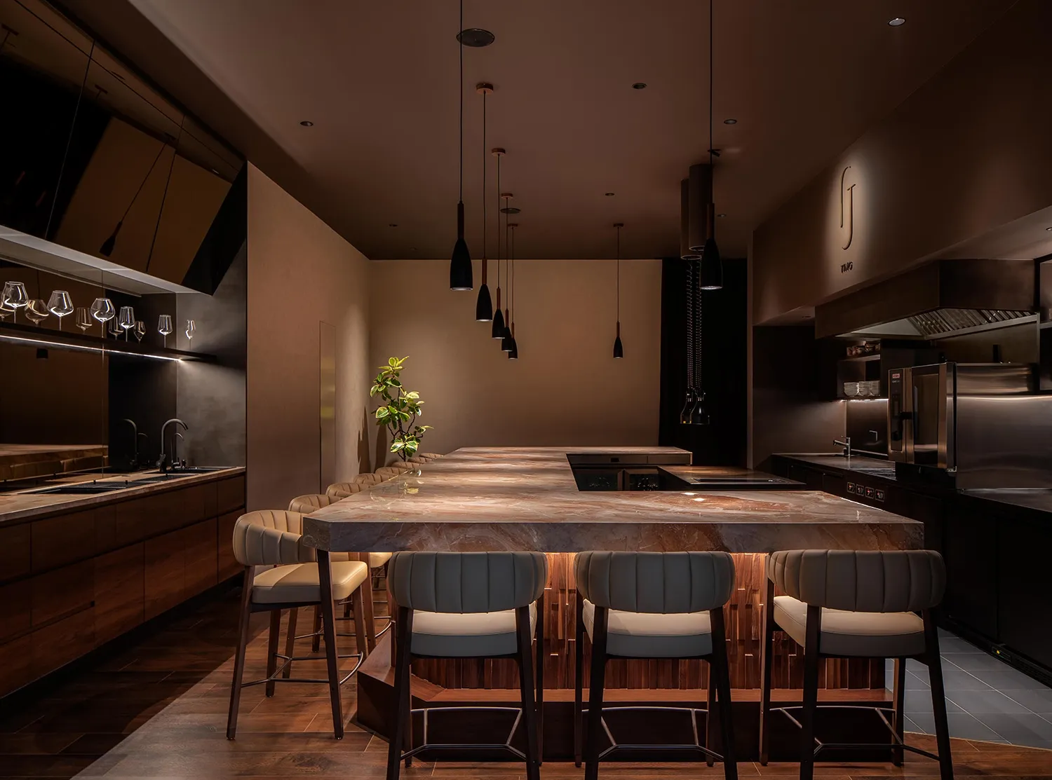 Warm and inviting kitchen with wooden floors, marble countertops, and a large island surrounded by chairs