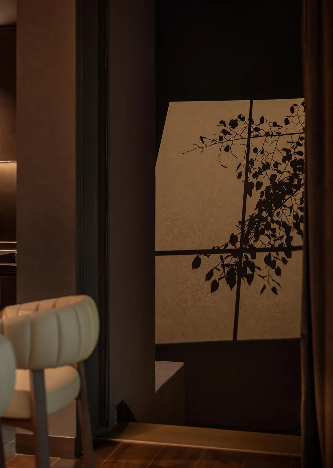 A white chair sits in front of a window with curtains, creating a cozy and inviting atmosphere