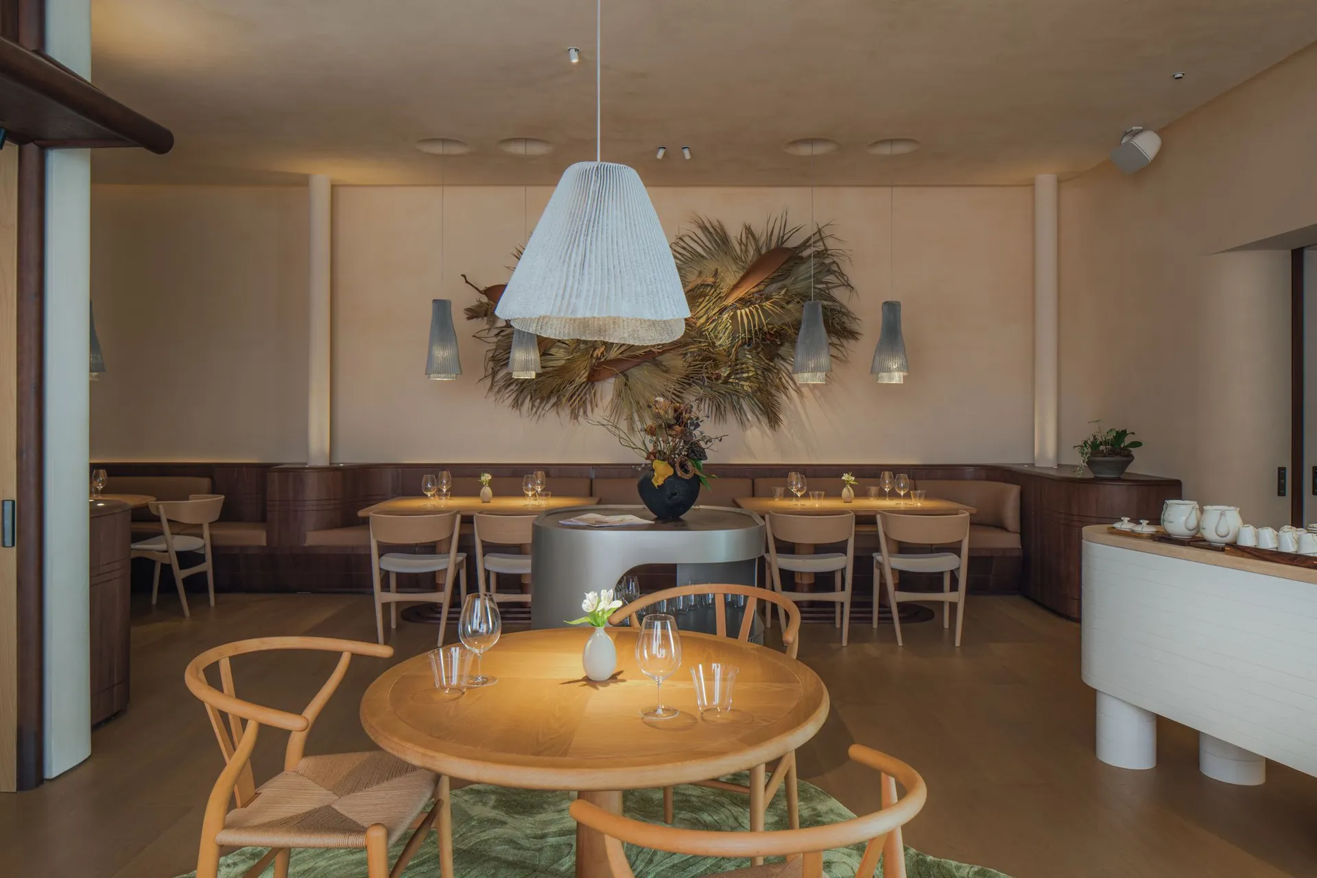 A warm and inviting dining area with wooden tables and chairs, wine glasses, and a comfortable atmosphere