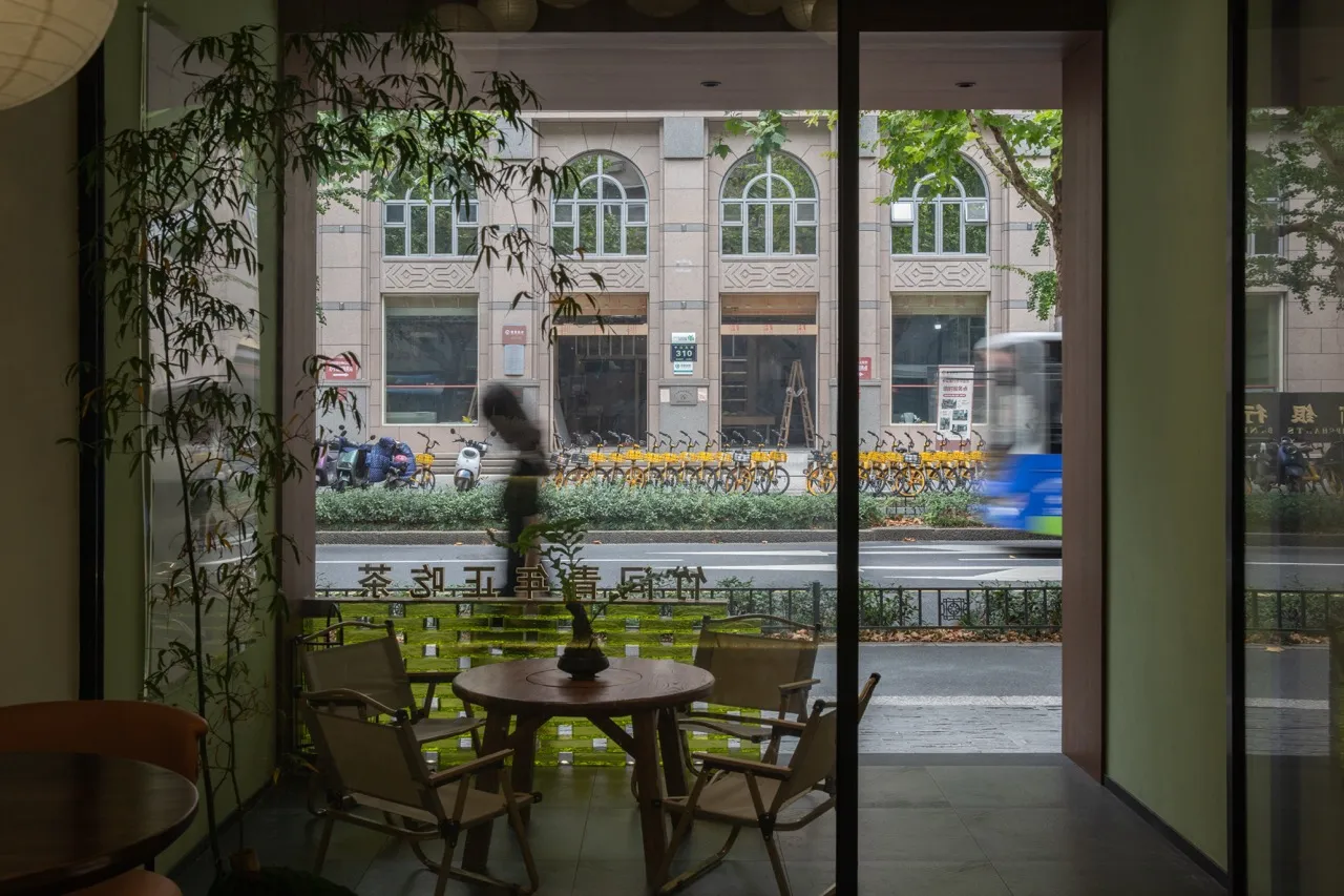 A casual dining area with a wooden table and chairs, surrounded by bicycles outside, in a restaurant or cafe setting