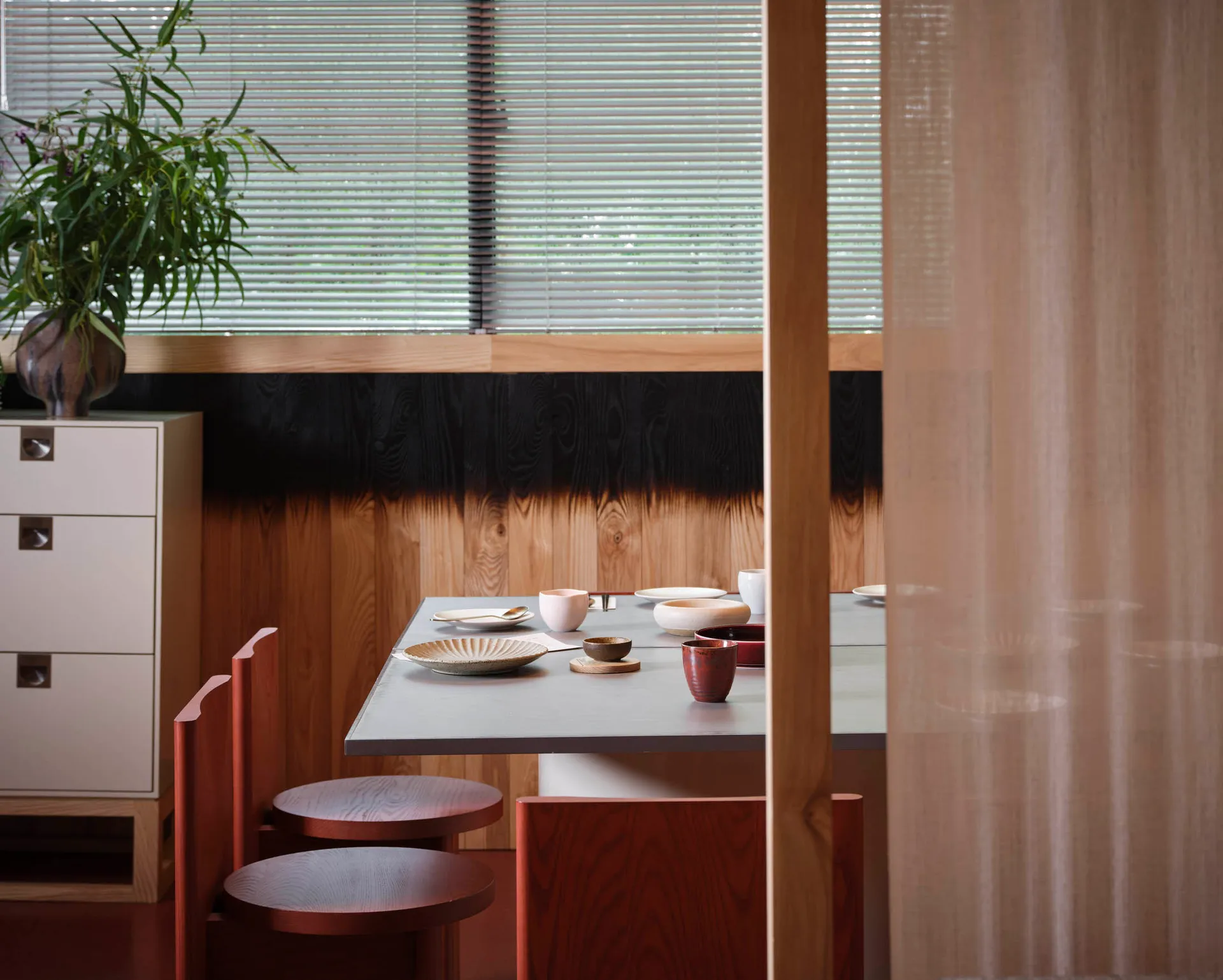 溫馨亞洲餐廳內部，一組餐桌擺放著碗、杯子和湯匙