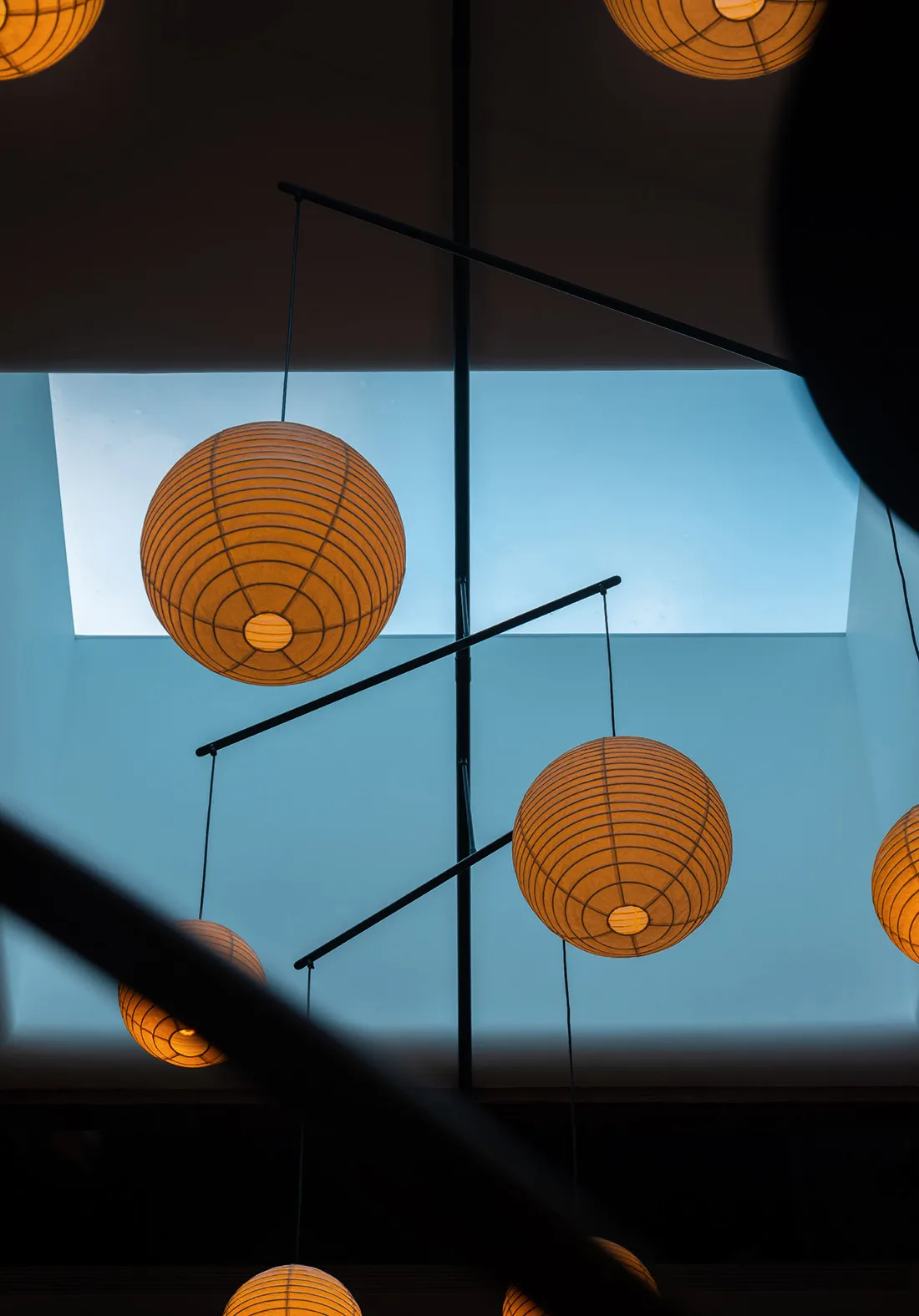 A warm and inviting interior space with five paper lantern-style ceiling lights providing soft illumination
