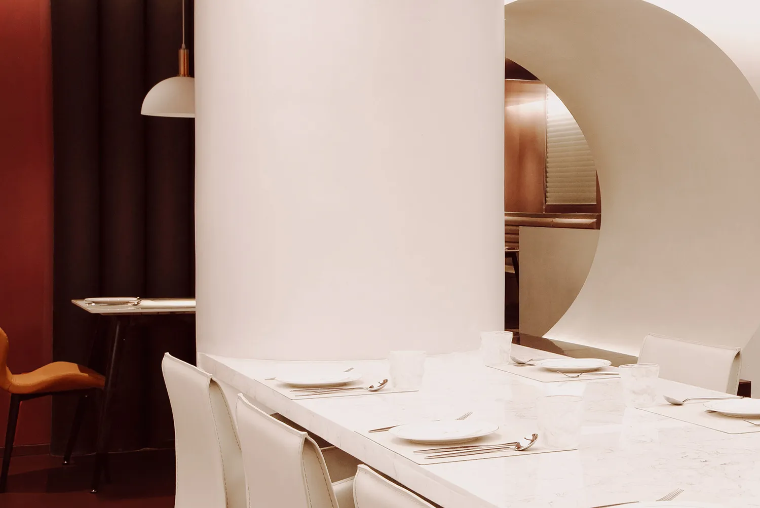 餐廳內的用餐區，白色餐桌擺放精緻瓷器、酒杯與各式餐具，營造出高雅氛圍