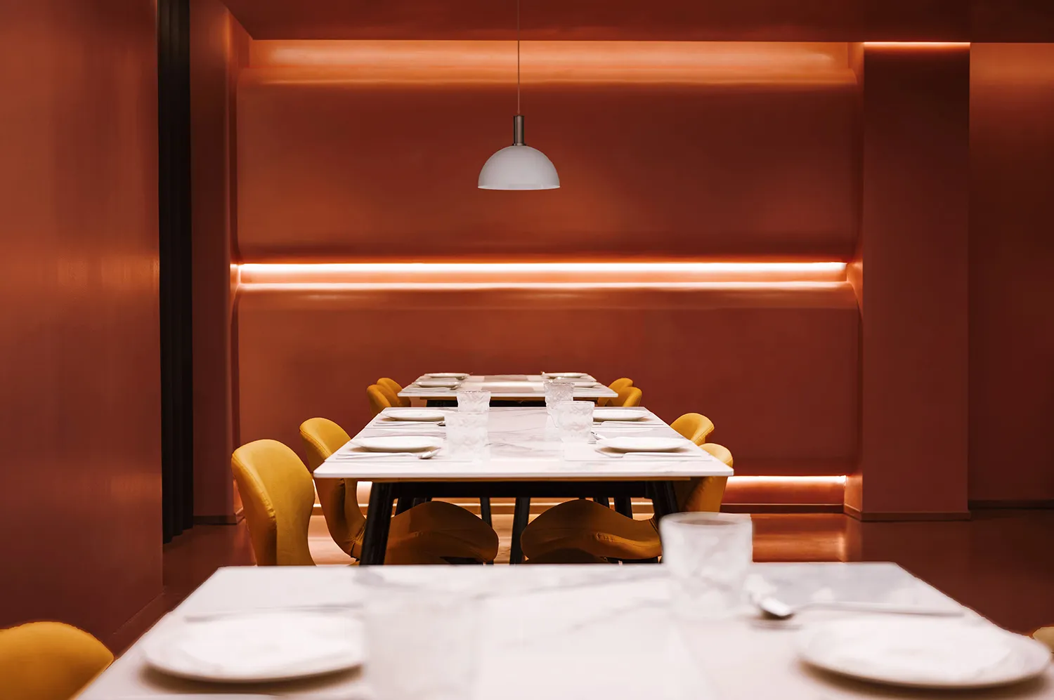 A formal dining area with a long wooden table and chairs set up for a meal, surrounded by a warm and inviting atmosphere