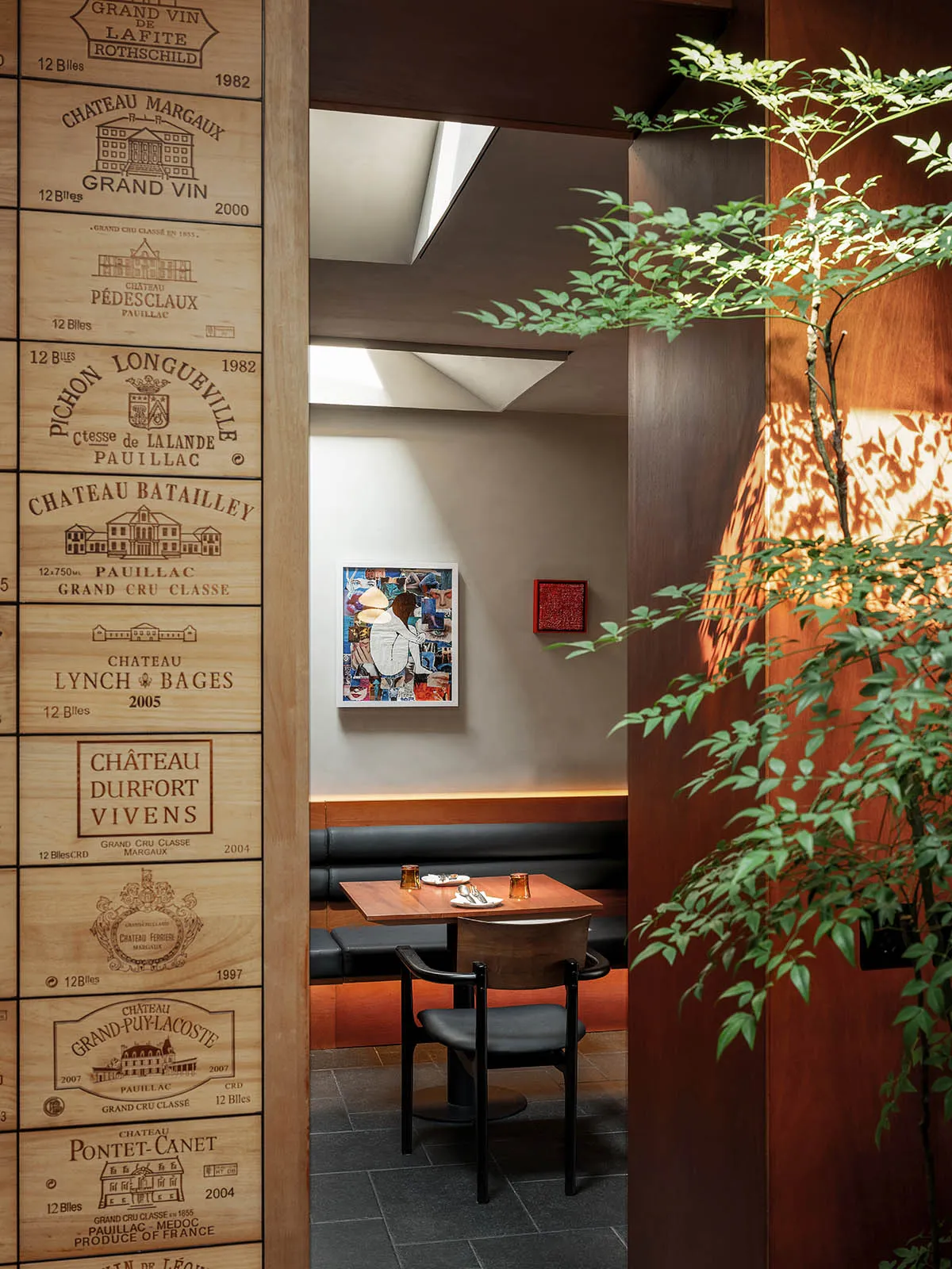 A dining area with tables and chairs, surrounded by wine bottles on the walls, creating a sophisticated ambiance