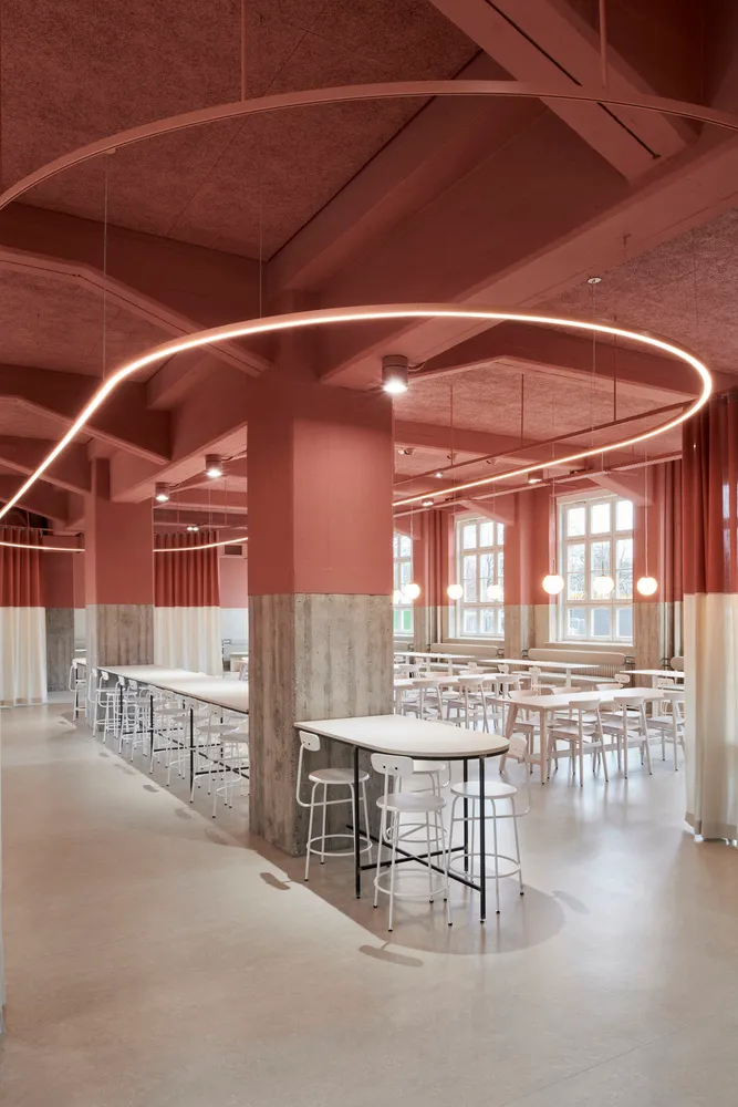Bright and inviting restaurant interior with pink walls, white stools, and natural light from windows