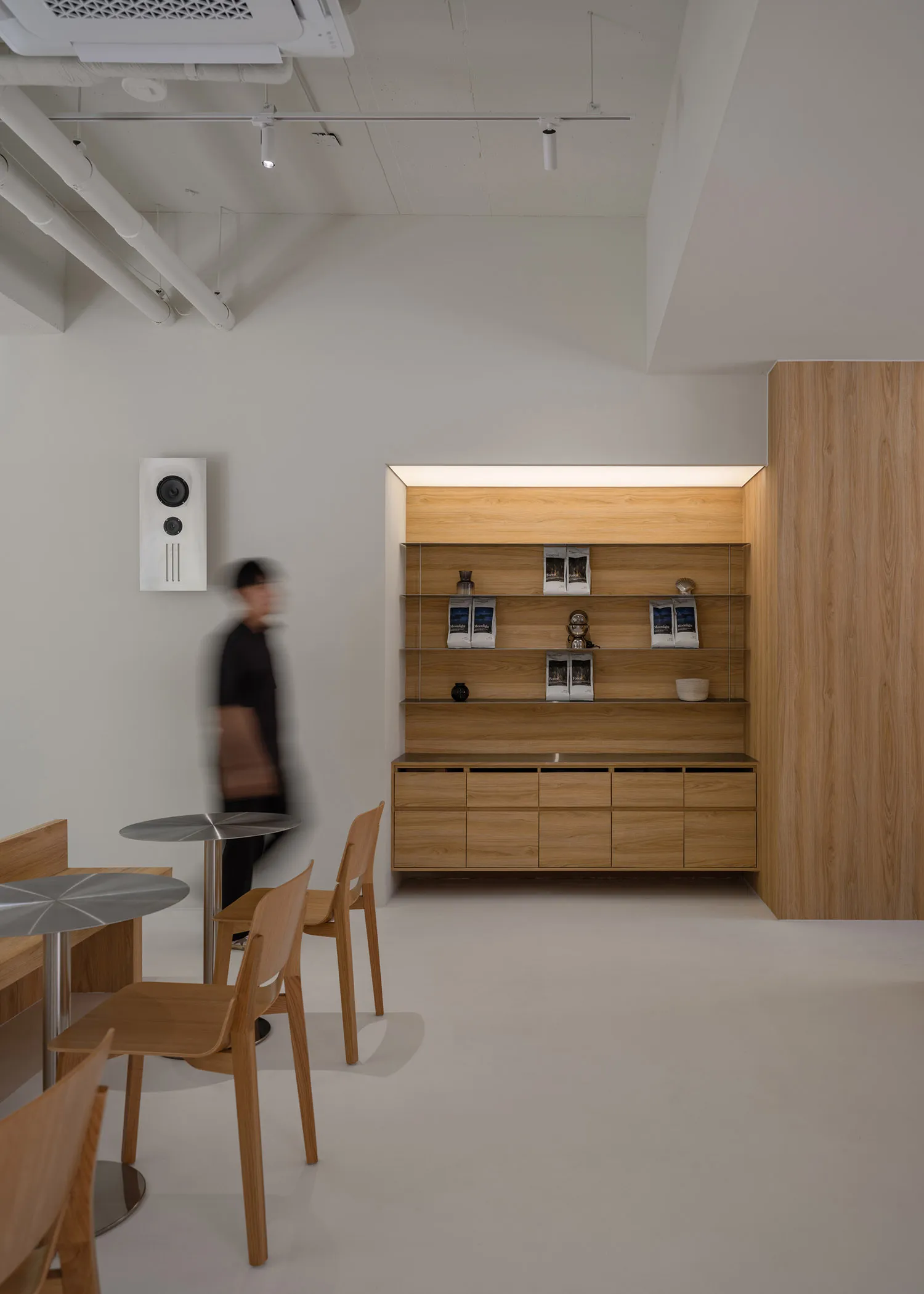 A clean and organized room with wooden floors and walls, featuring two chairs and three bowls on surfaces