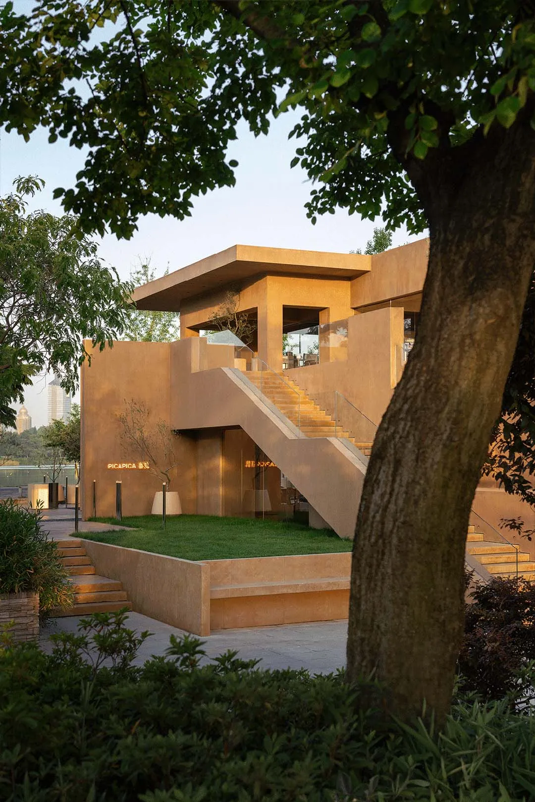 A rustic building with a stone facade and concrete stairs, captured during sunset with warm hues