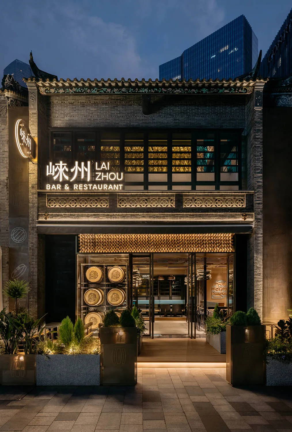 A modern Asian restaurant with a spacious interior, bar area, and potted plants, creating a welcoming atmosphere