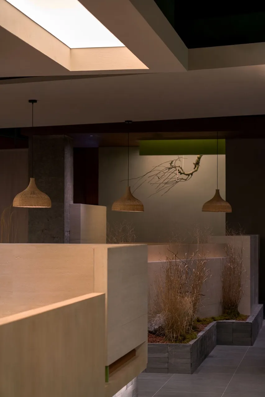 A modern living and dining area with a dining table, chairs, and hanging lights creating a warm atmosphere