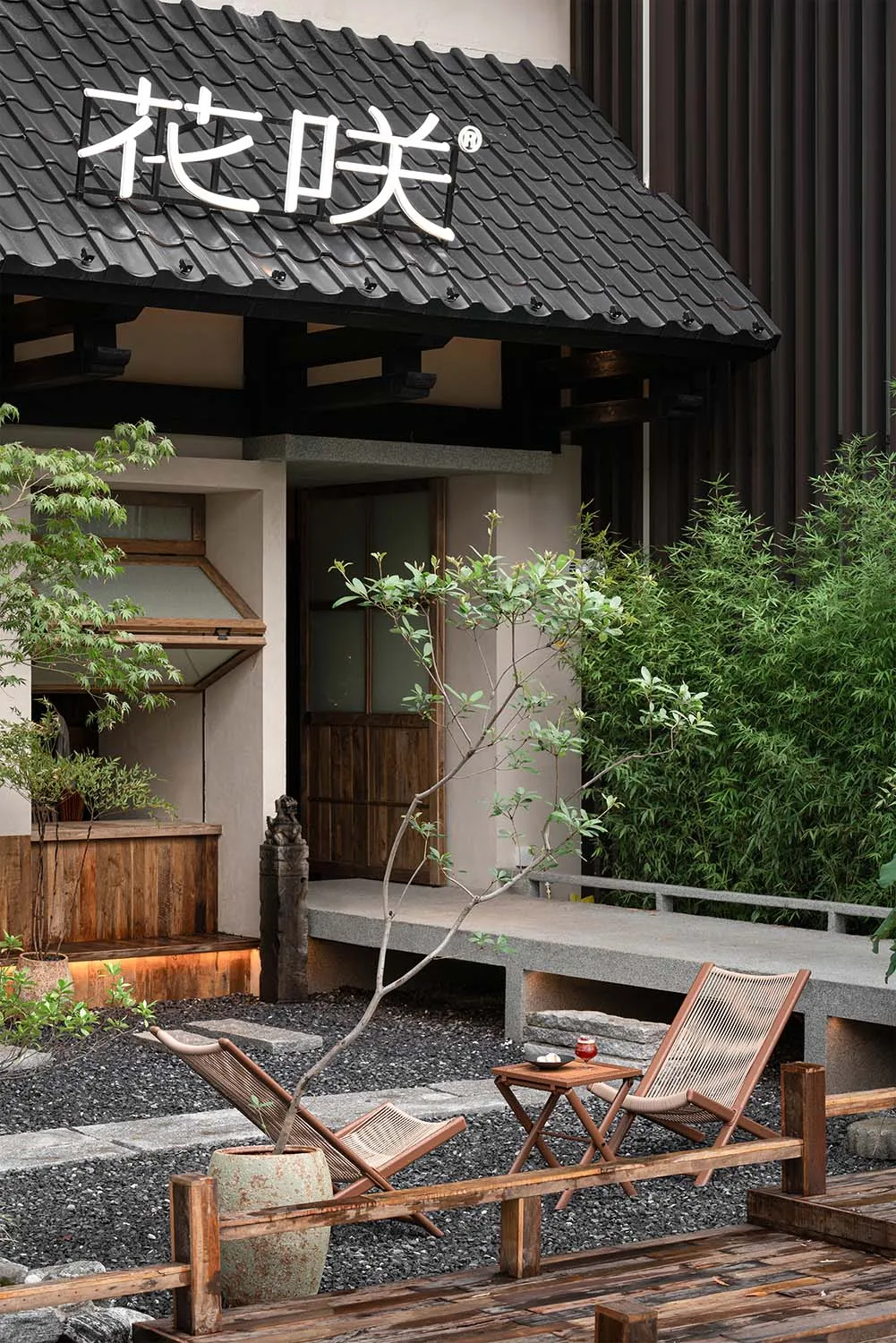 Serene outdoor space with a wooden deck, stone floors, a patio area, and natural elements