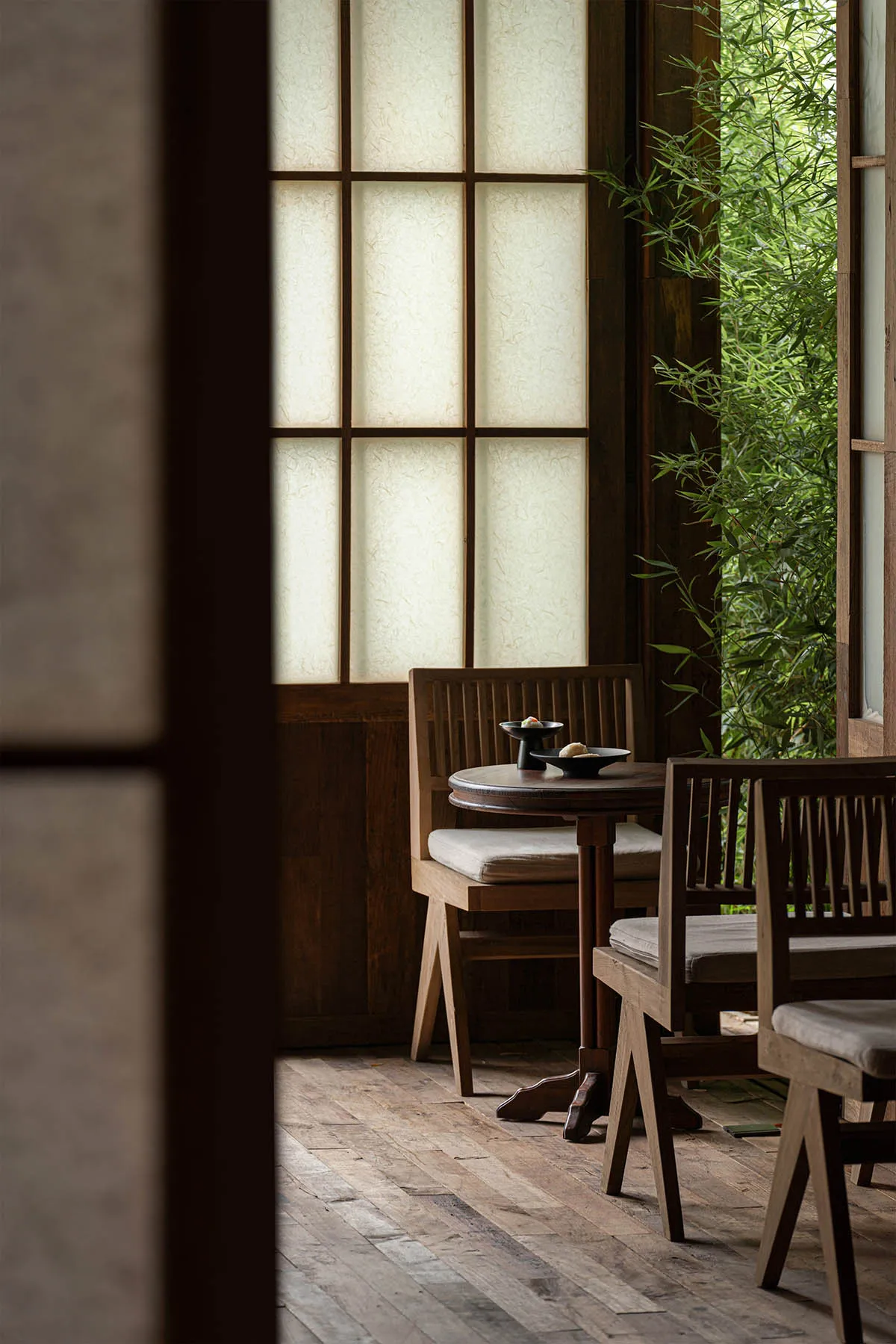 A warm and inviting dining area with wooden chairs and tables arranged around a central table, creating a comfortable seating arrangement