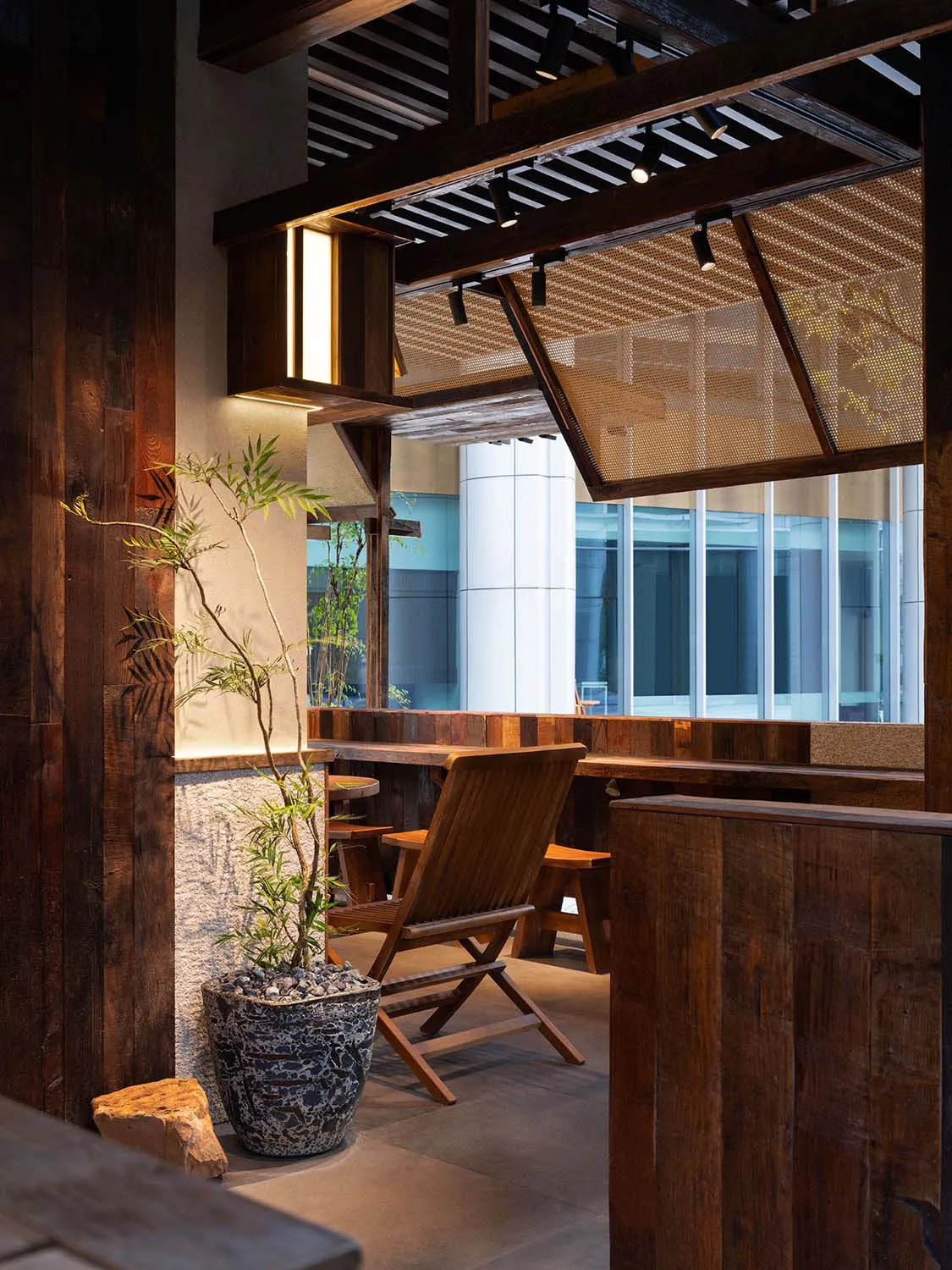 A warm and inviting dining space with a wooden chair and a potted plant in front of a window