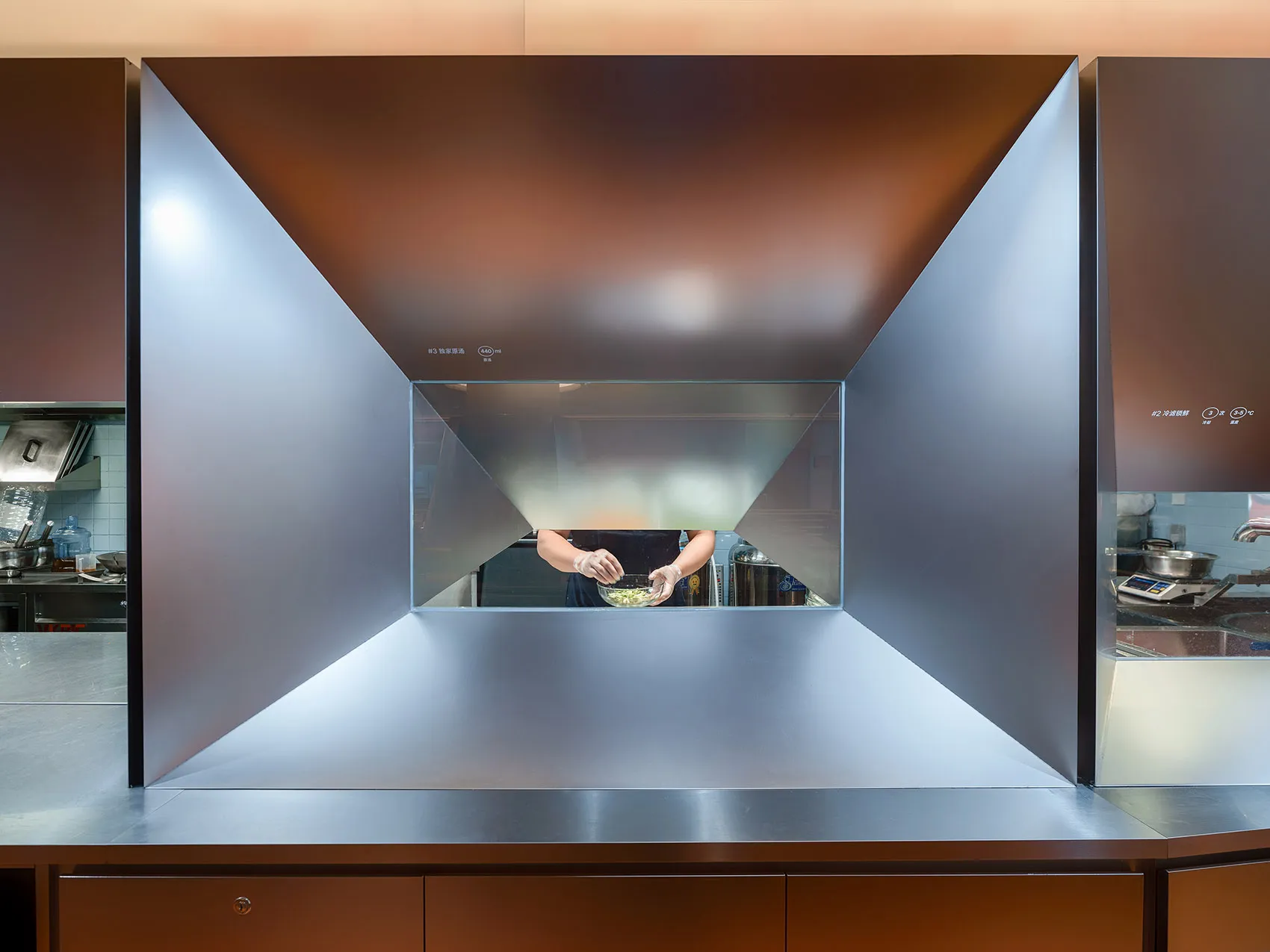Industrial kitchen with a stainless steel counter, sink, and oven, featuring a professional atmosphere