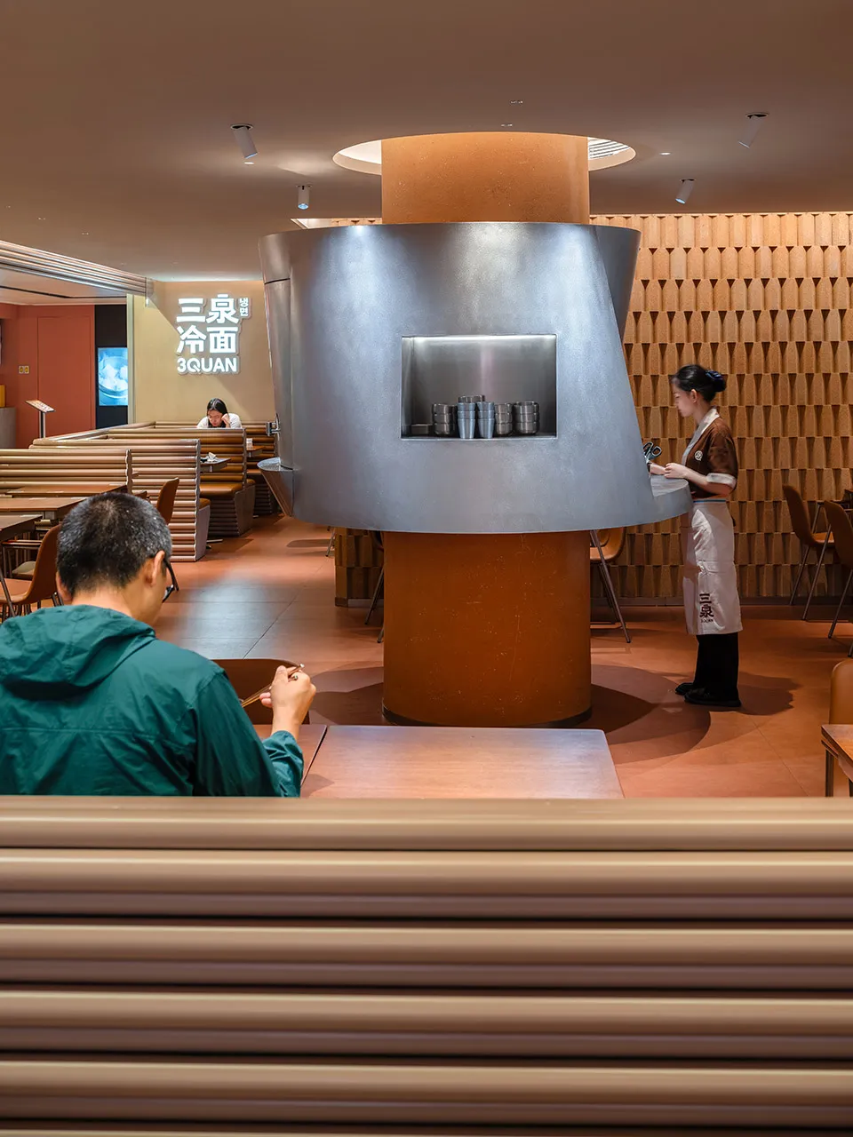 現代亞洲餐廳，設有餐桌、椅子與木飾面板，營造溫暖親切的氛圍