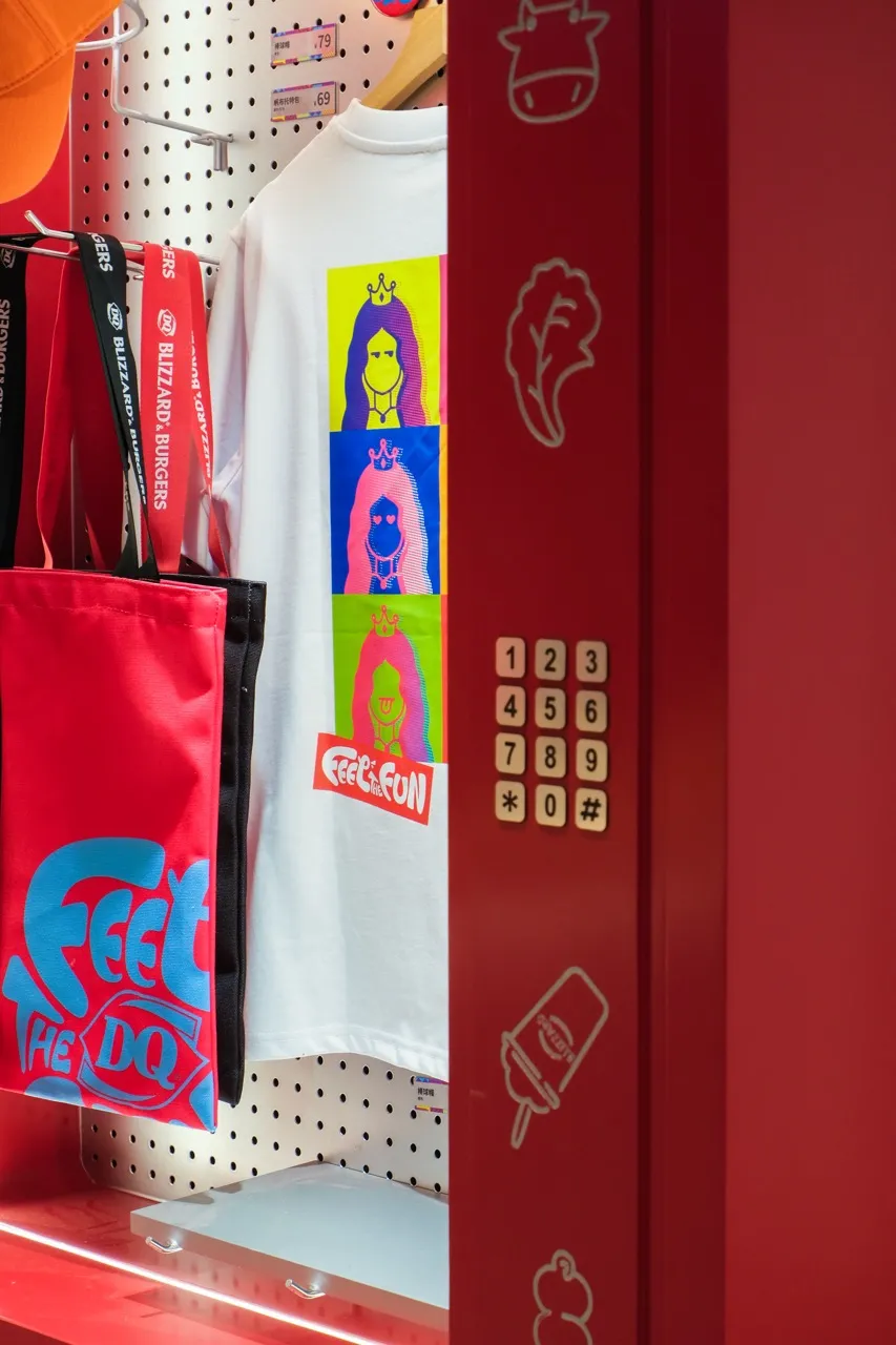 A casual office entrance with a red door, bags, and t-shirts on the wall, creating a sense of organization and personality