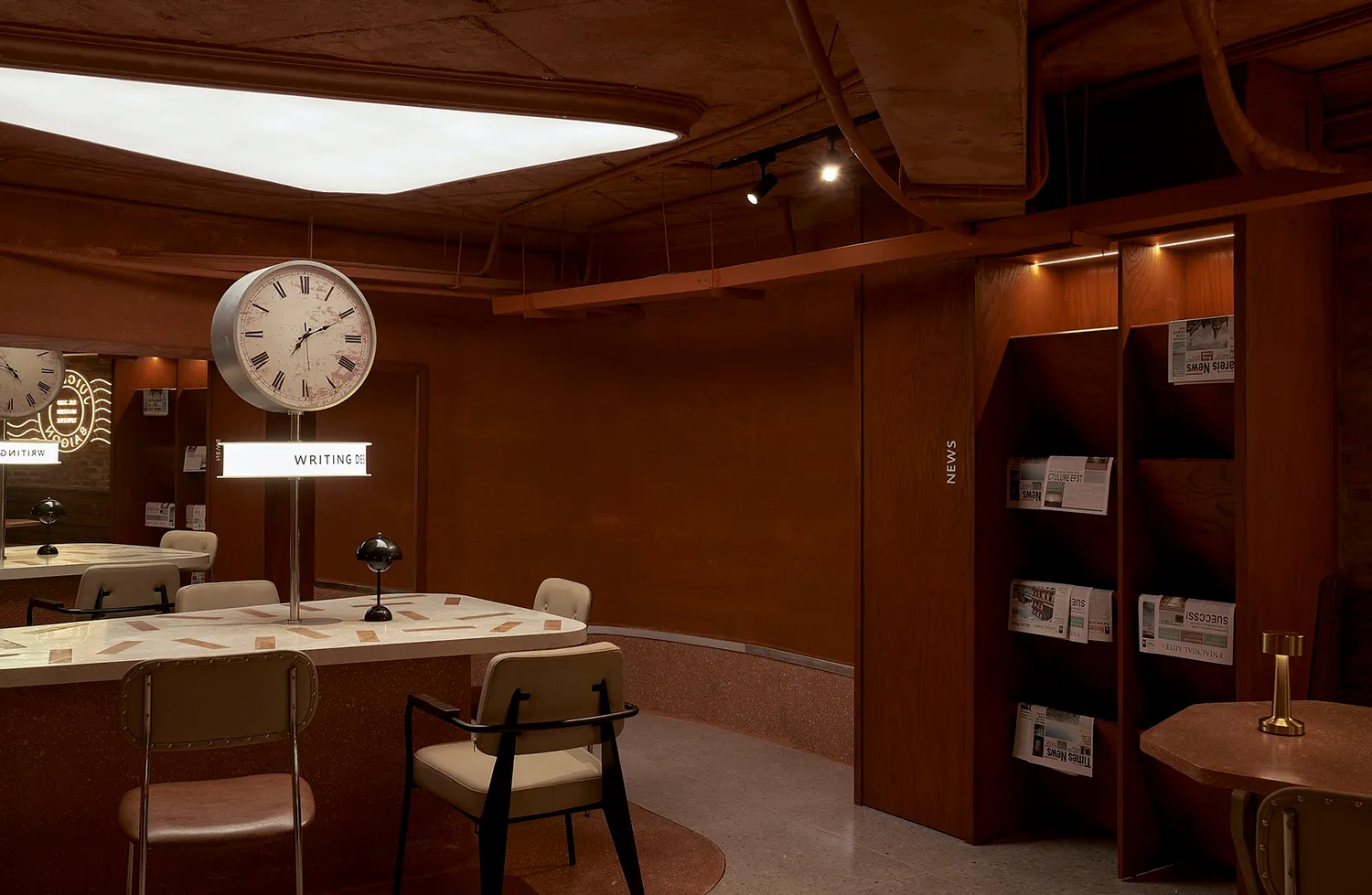A modern showroom with a large clock on display, two chairs, and a table, set in a well-lit space with a bright atmosphere