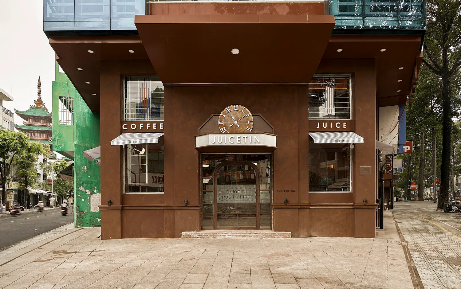 Exterior view of a brown building with a clock on its side, a storefront window, and a cozy atmosphere