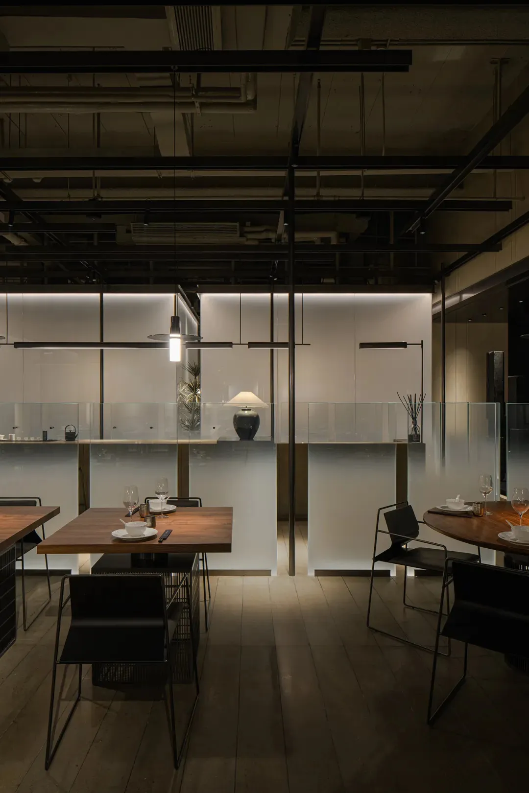 Elegant restaurant with glass walls, wooden floors, and minimalist decoration, featuring multiple dining tables and chairs
