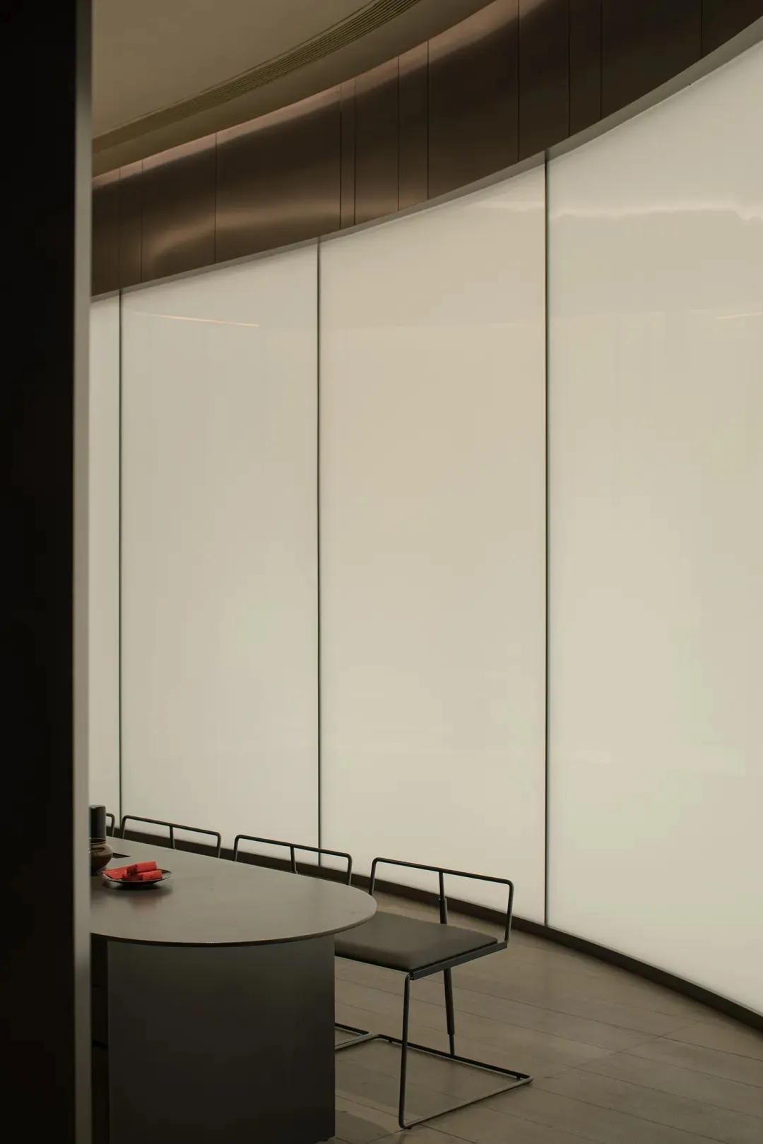 Empty room with white walls, glass doors, and four chairs placed symmetrically on either side