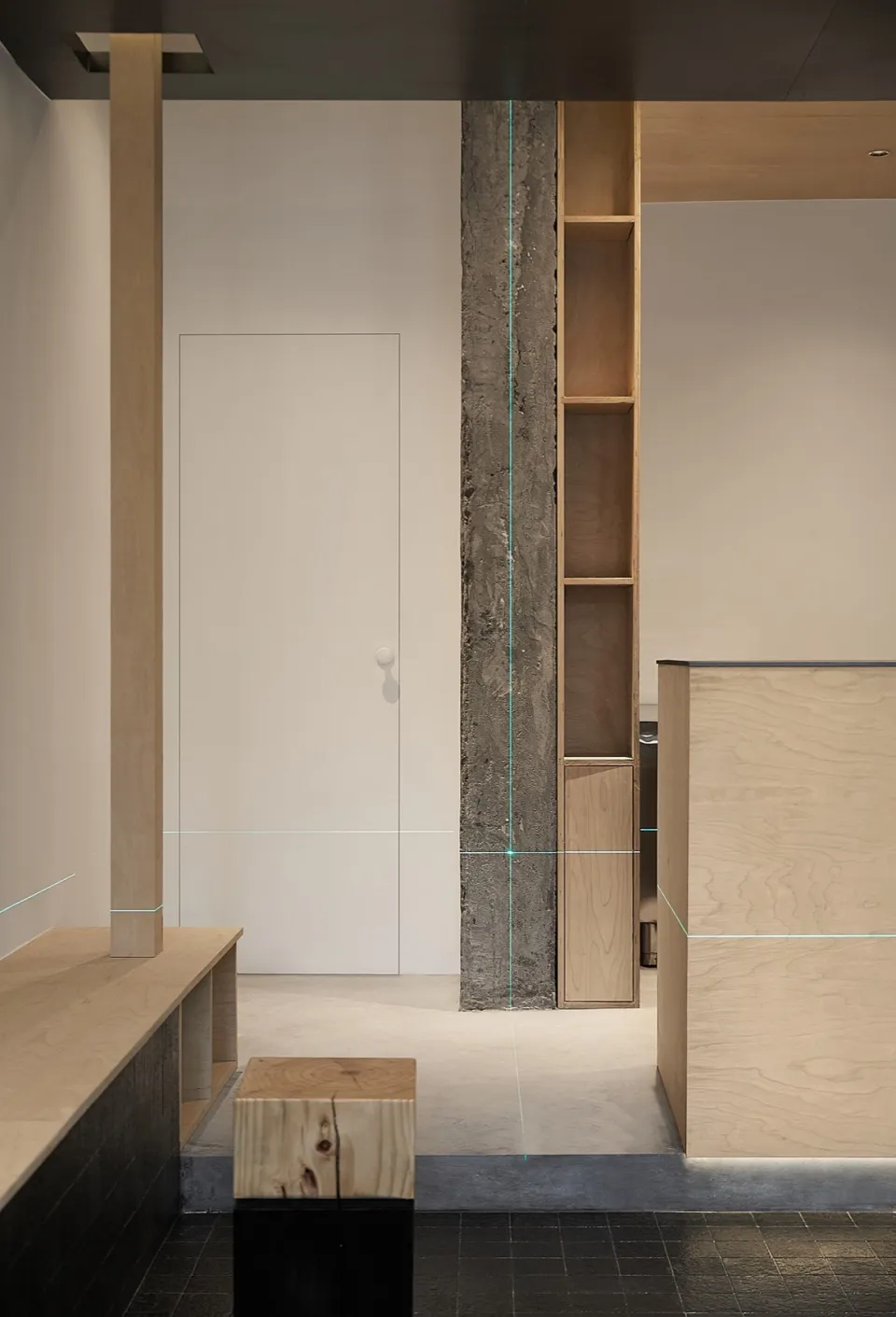 Modern open-plan kitchen with a wooden countertop, sink, refrigerator, and natural light from windows
