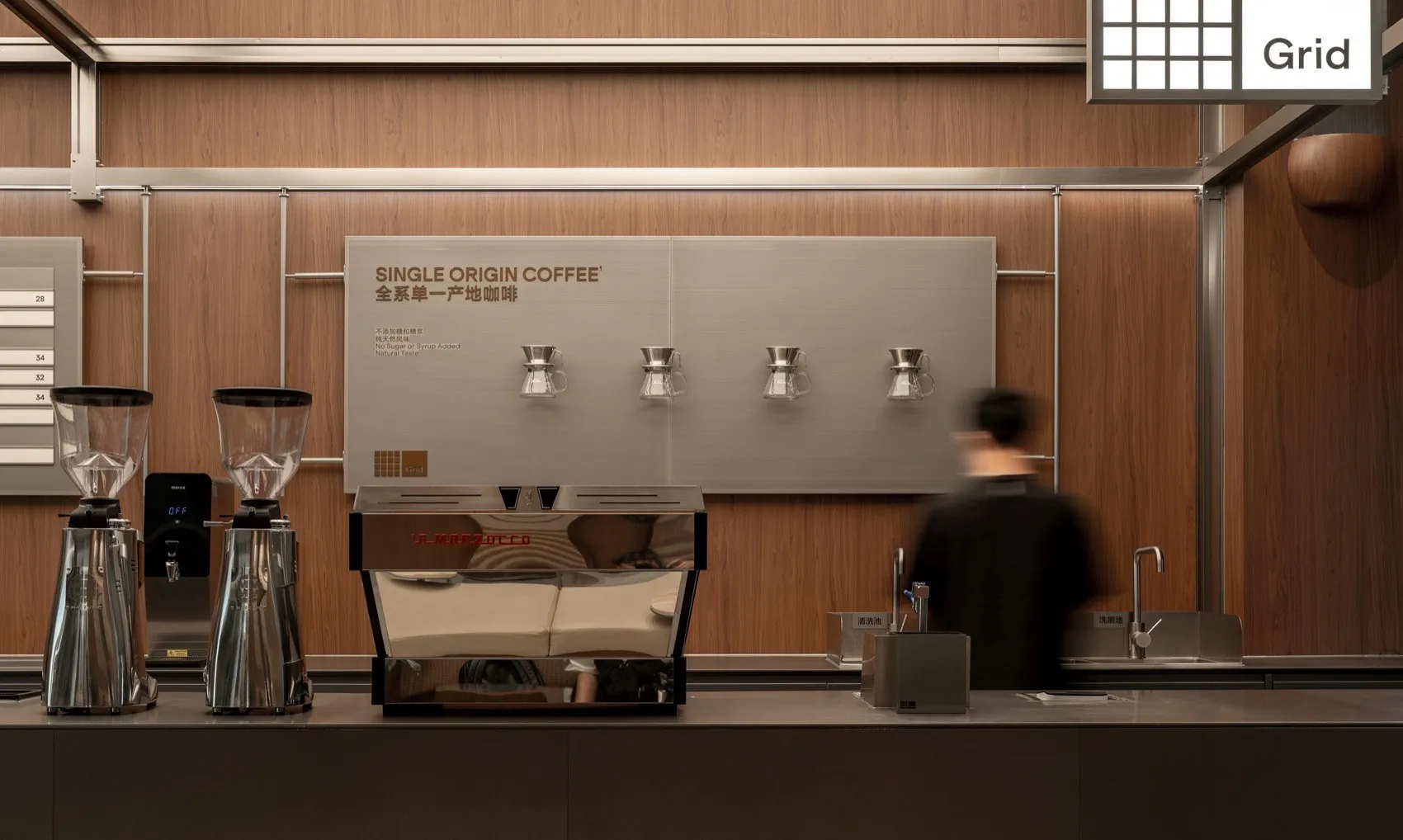A modern coffee shop with a wooden counter, cappuccino machine, and various coffee products on display