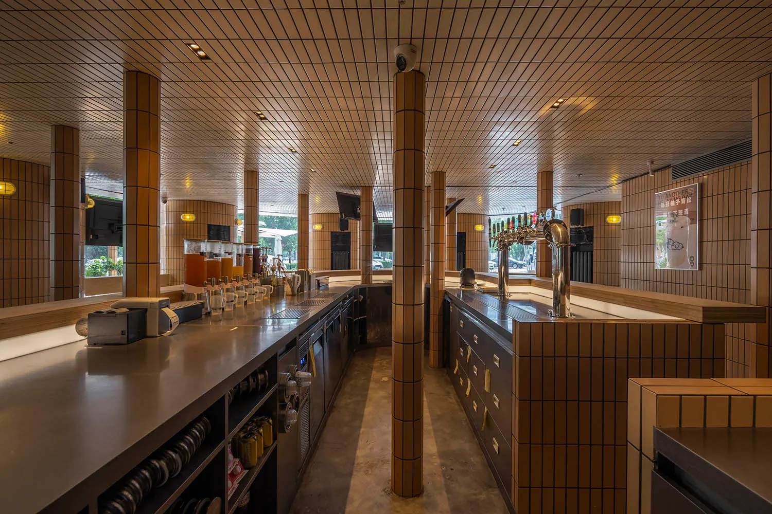 Modern bar area with brick walls, beer taps, and bottles on the countertop