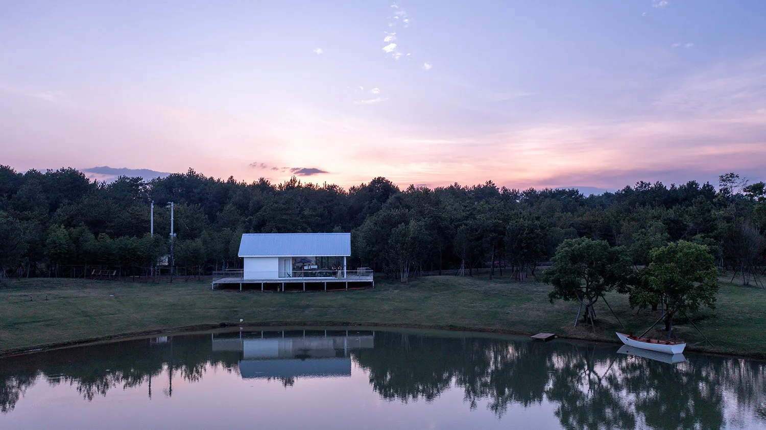 寧靜的山坡木造住宅俯瞰湖泊，配有寬敞露台與兩張椅子