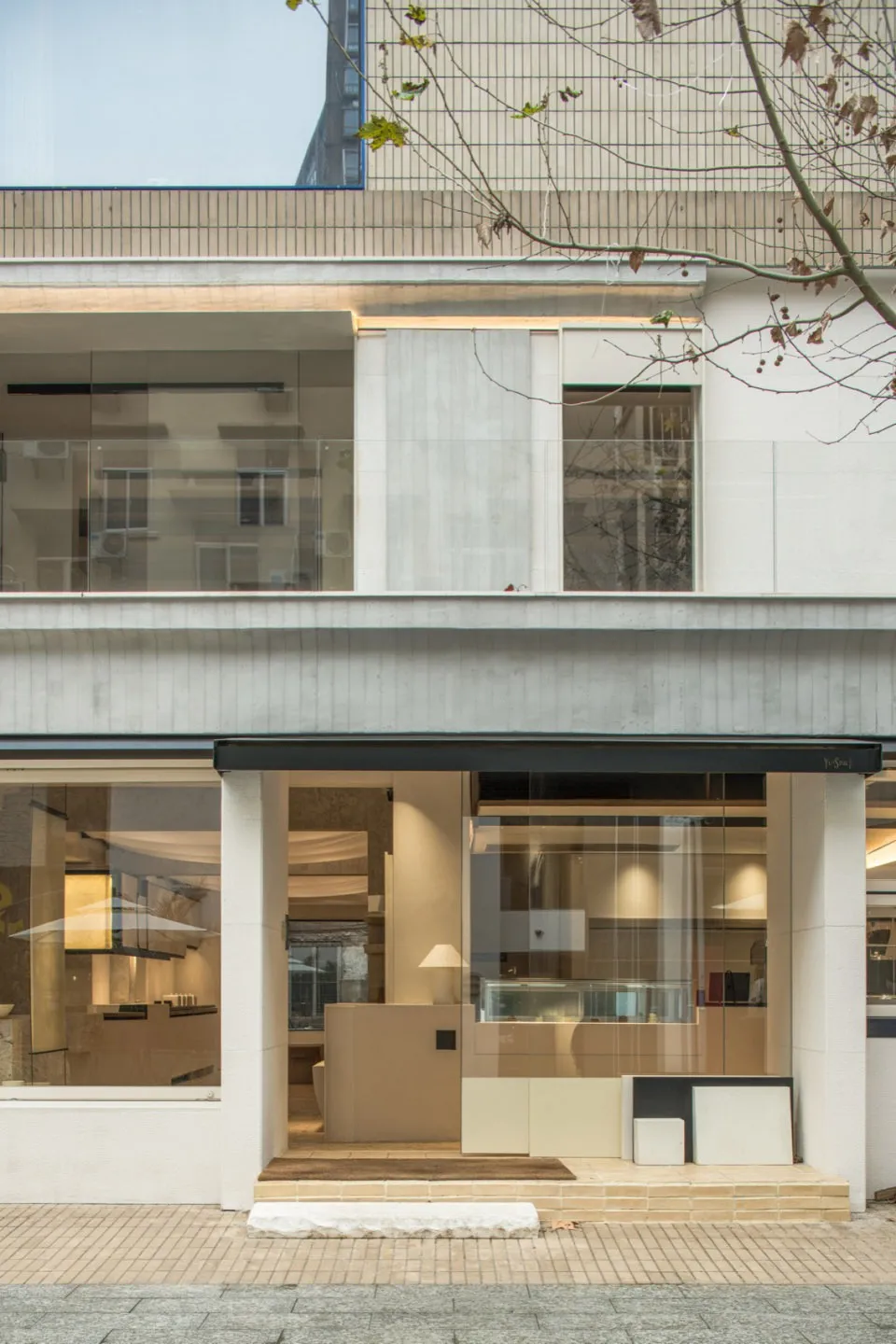 Bright and inviting interior design showroom with a large window, chairs, dining table, couch, and various furniture options