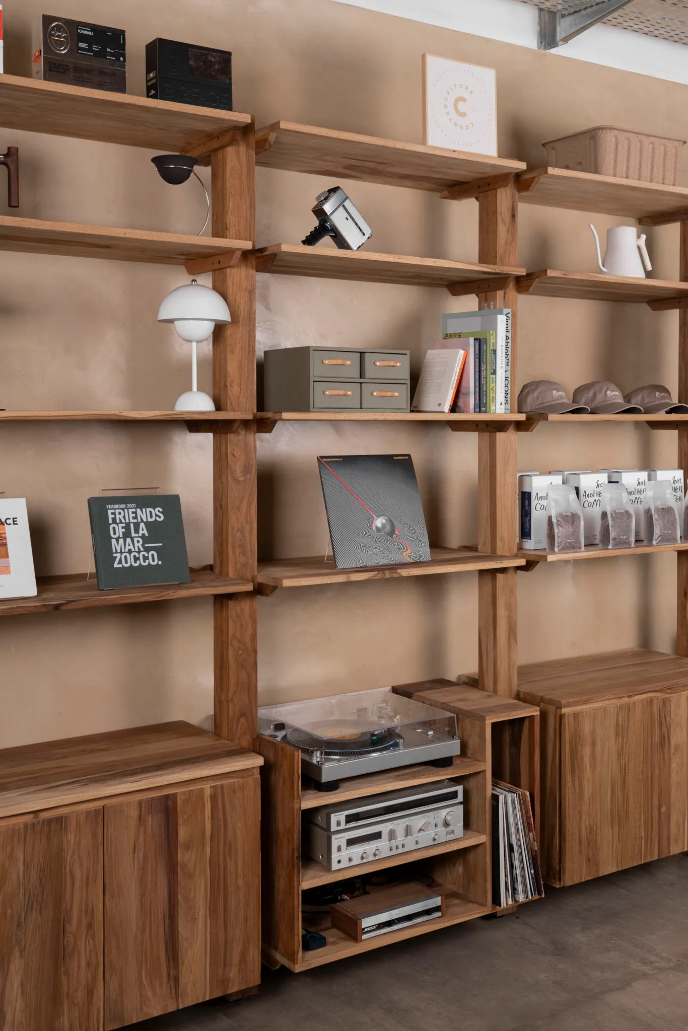 A well-organized bookshelf with books and a record player, creating a cozy atmosphere for reading and listening to music