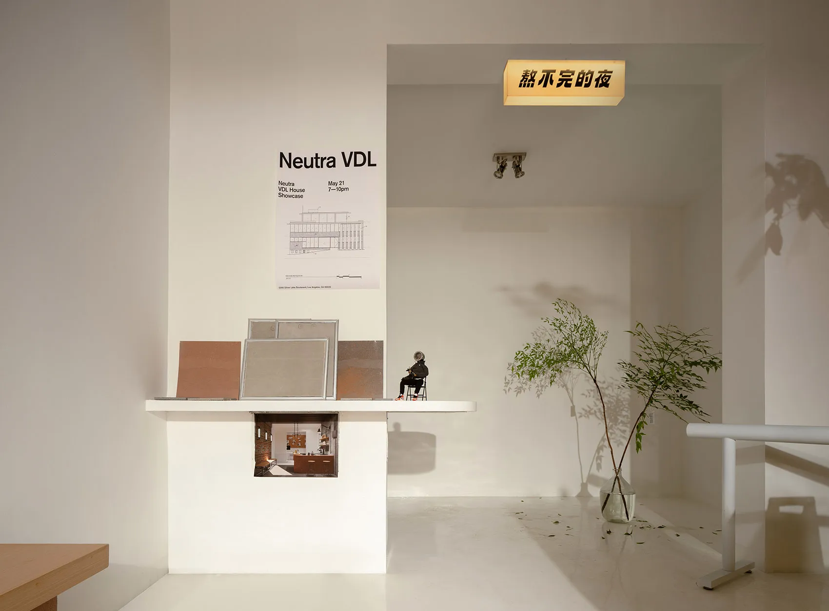 A modern showroom with two tables, chairs, and potted plants, creating a clean and inviting atmosphere