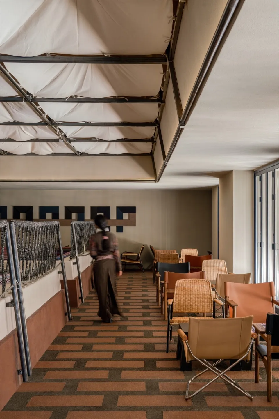 A hallway lined with chairs and tables, featuring two dining tables and a comfortable, inviting atmosphere