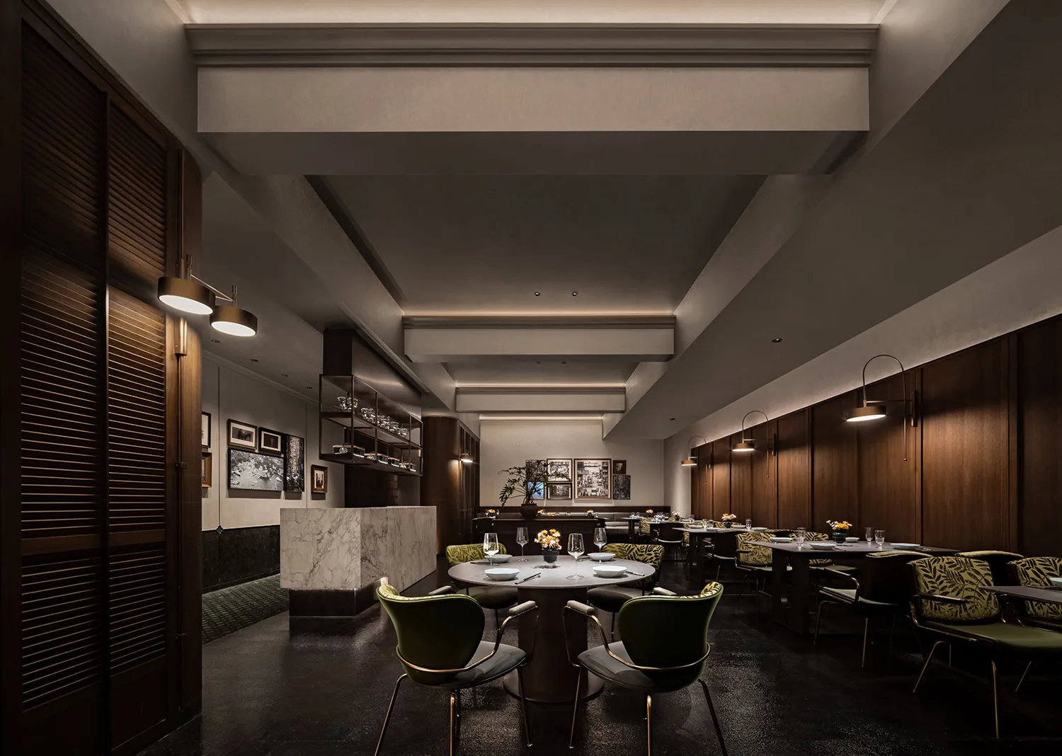 A well-lit dining area with multiple tables and chairs, wine glasses, and a modern interior design