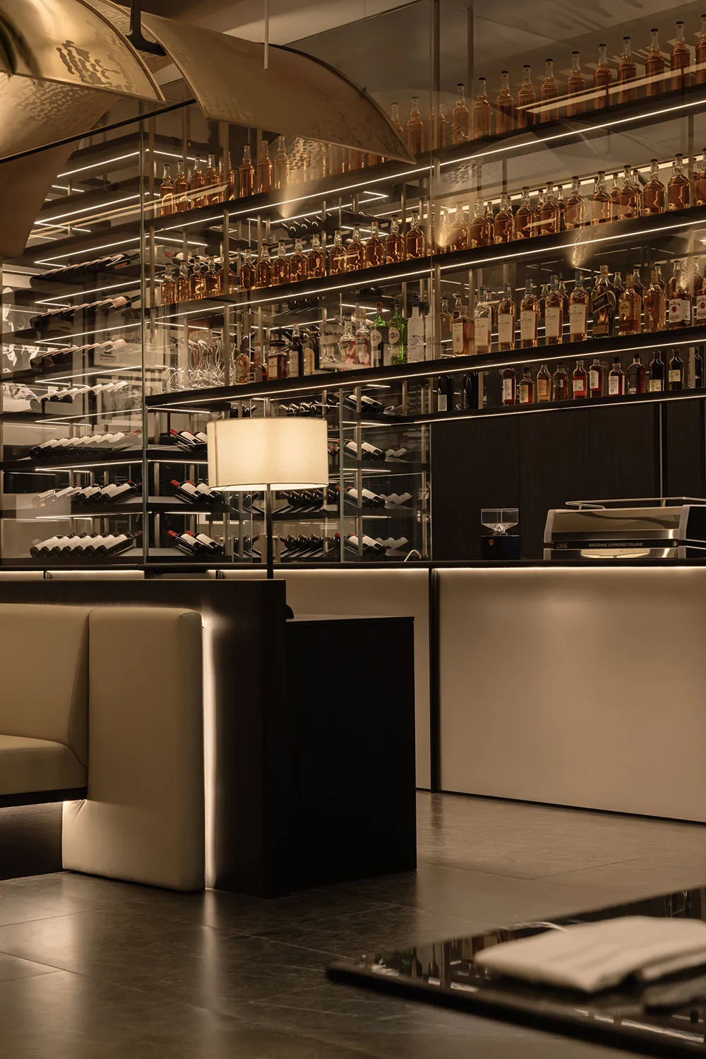 Elegant bar area with wine bottles, glasses, and cups on a countertop, creating a sophisticated atmosphere for enjoying a fine drink