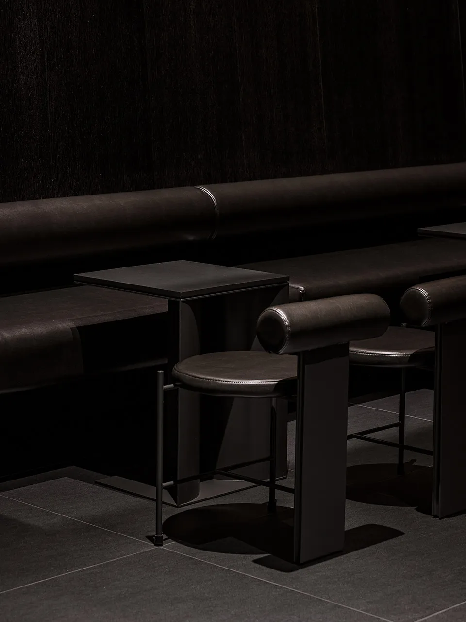 Cozy cafe interior with brown leather benches, wooden tables, and chairs, creating a warm and inviting atmosphere