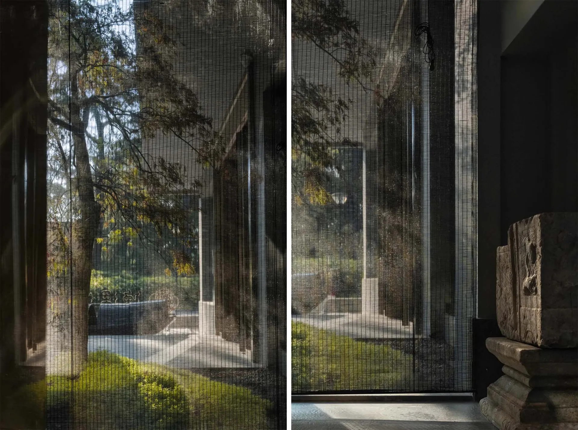 A house with a calm atmosphere, featuring large windows with blinds and a smaller window with curtains, and a bench near the windows, surrounded by trees and sunlight