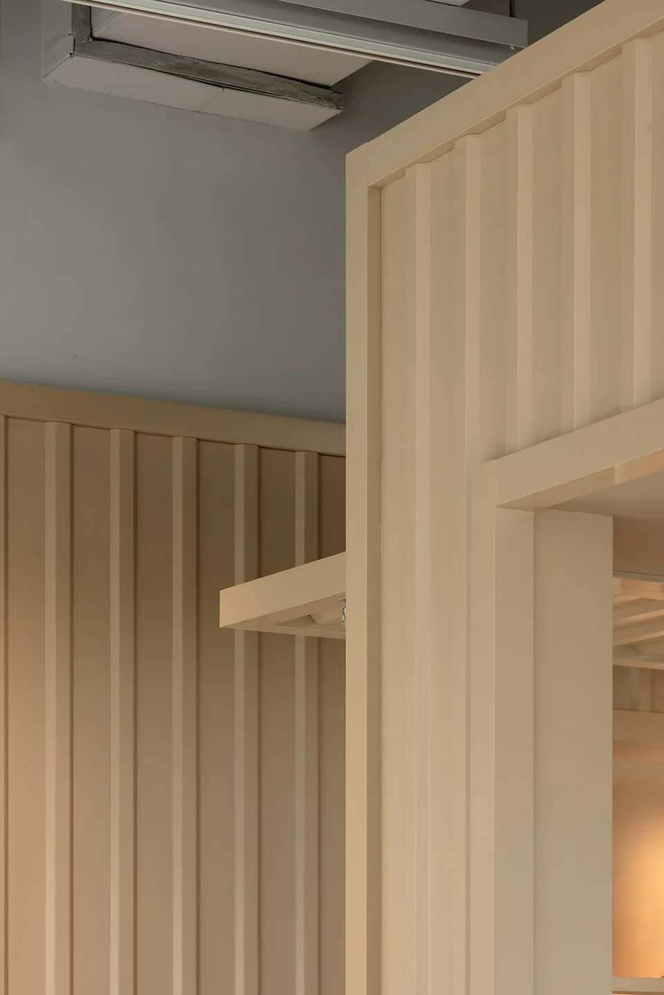 A wooden cabinet with two doors in a room with a blue wall, adding a contrasting element to the space