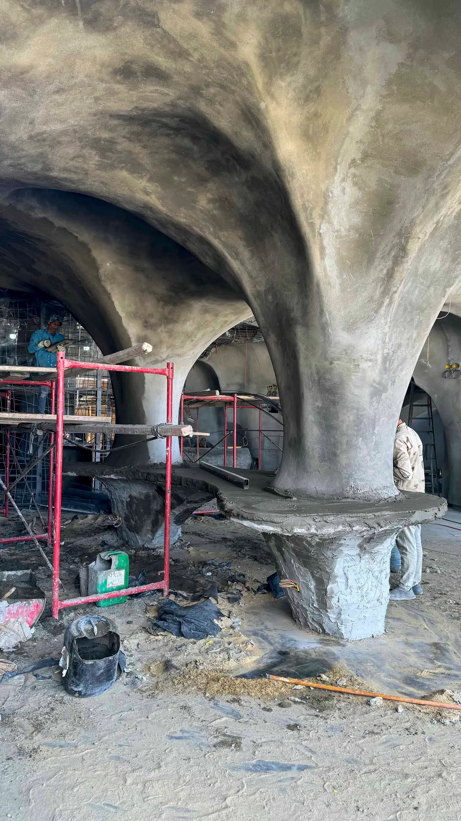 Construction site with a stone archway, workers, tools, and a collaborative atmosphere