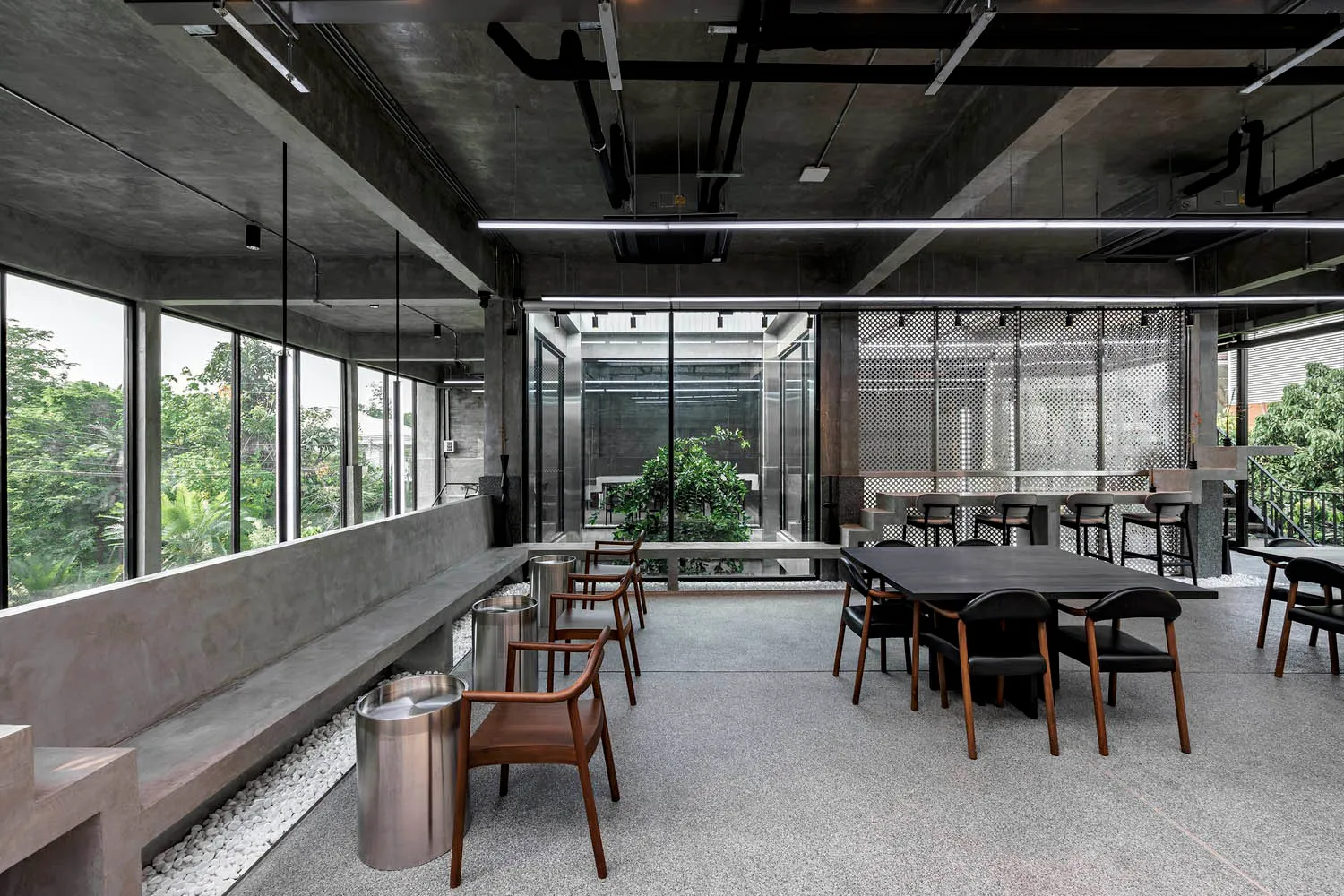 A spacious dining area with multiple tables and chairs, modern design, and minimalistic decoration