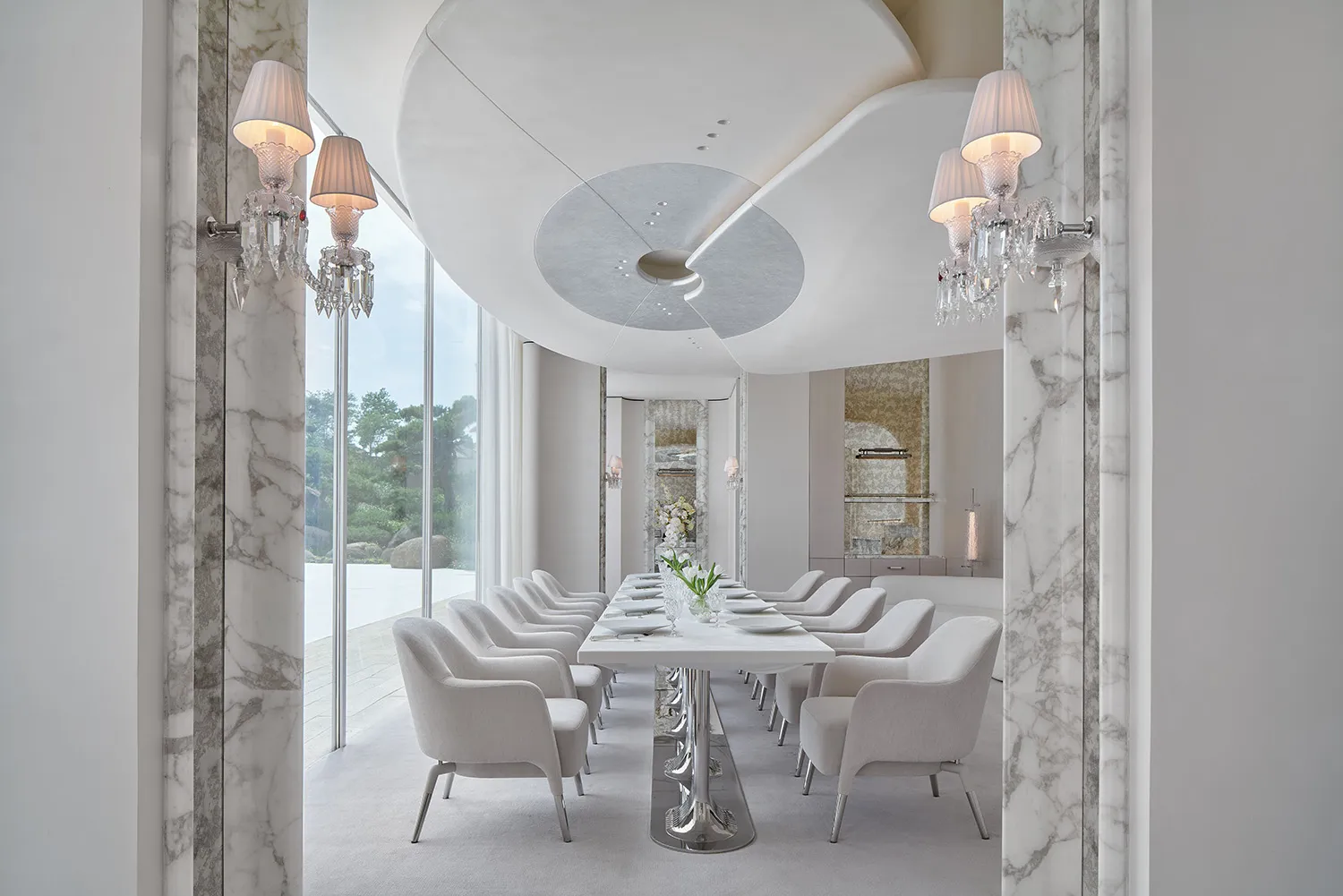 Elegant dining area with a round glass table surrounded by white chairs, set in a sophisticated room designed for formal gatherings