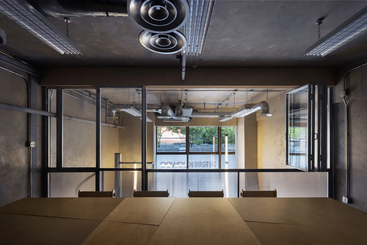 Bright and inviting office space with a large wooden table and chairs, surrounded by natural light from windows