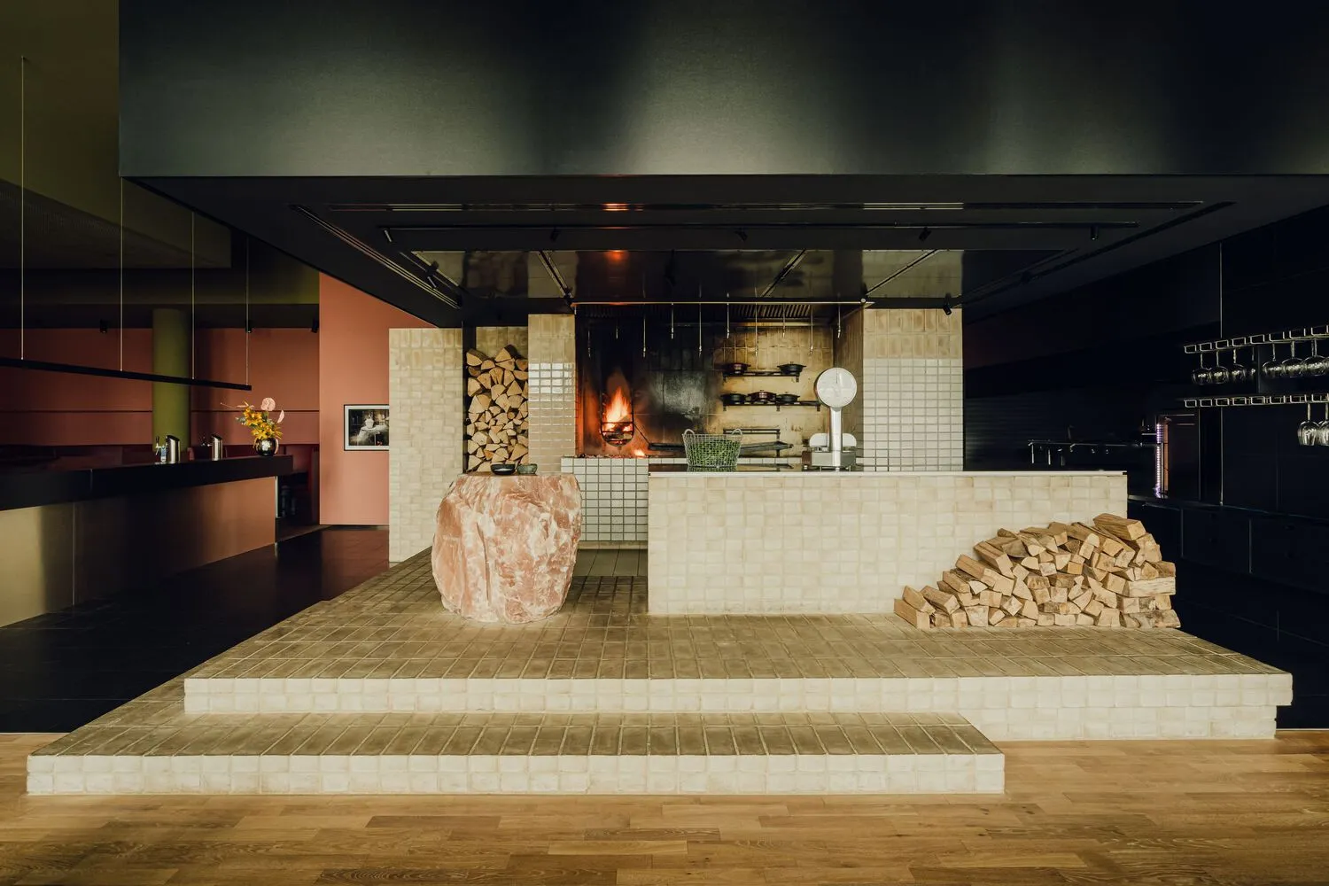 Modern kitchen with a fireplace, white tiles, and bottles, creating a warm and inviting atmosphere