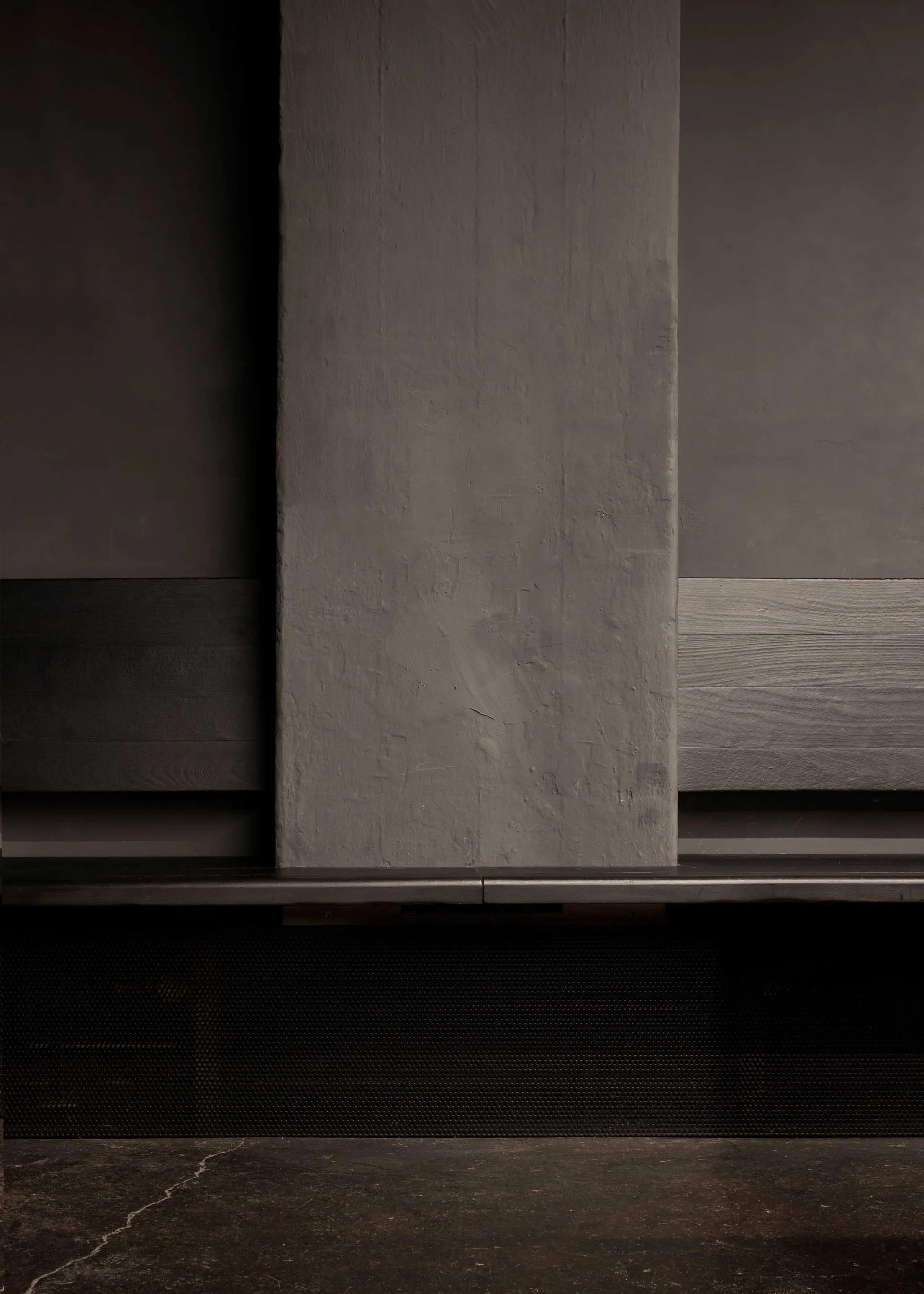 Exposed concrete wall with a weathered and worn finish, possibly from a building interior