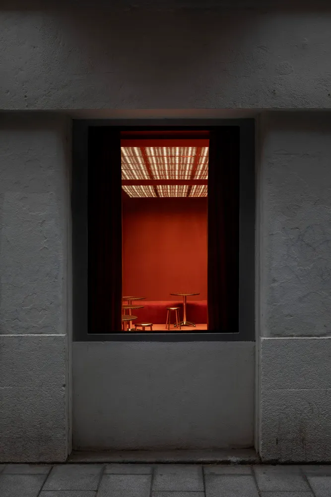 A warm and inviting dining area with orange walls, a dining table, and two chairs, creating a cozy atmosphere