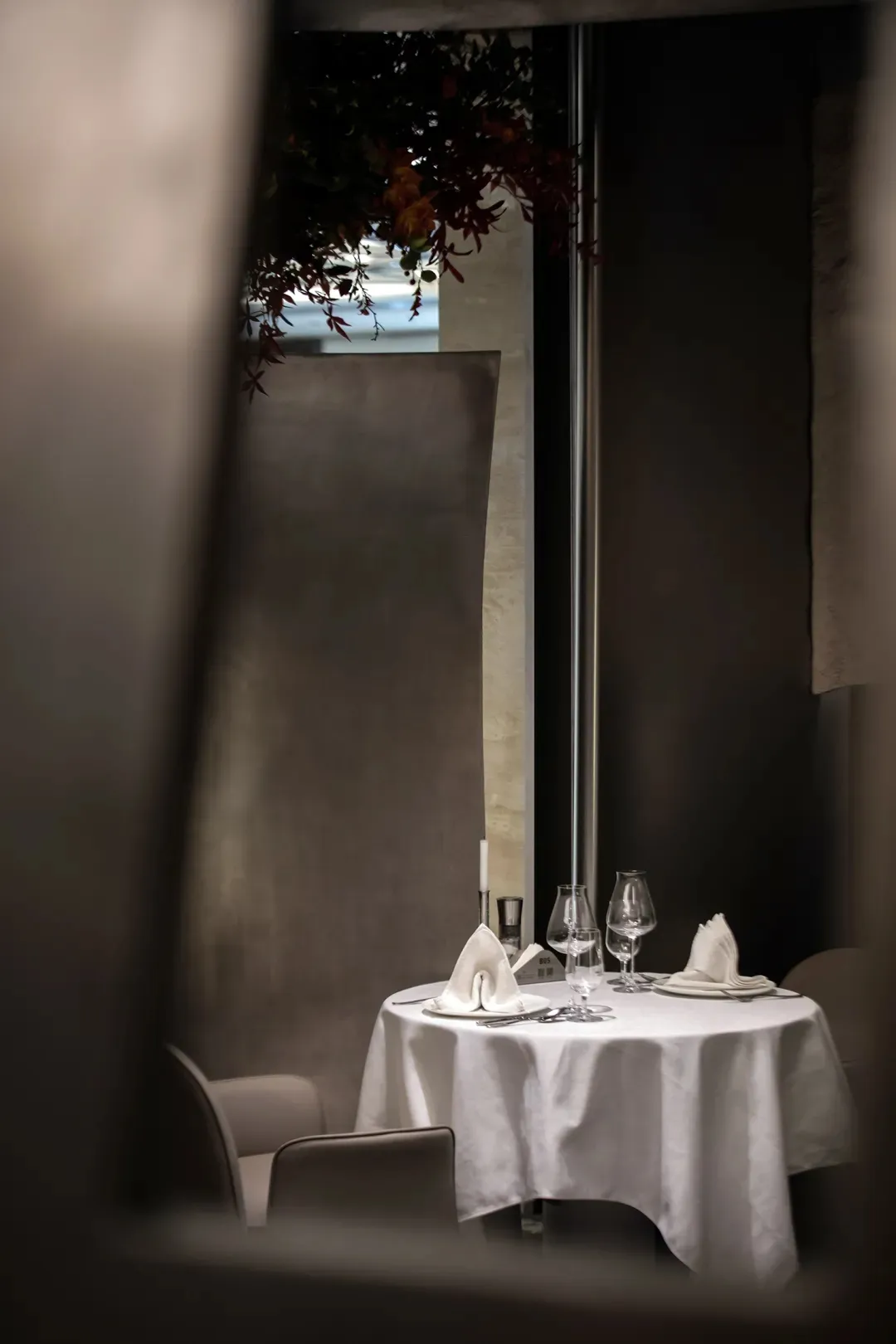 Sophisticated dining area with a white table set, wine glasses, plates, and napkins, surrounded by inviting atmosphere